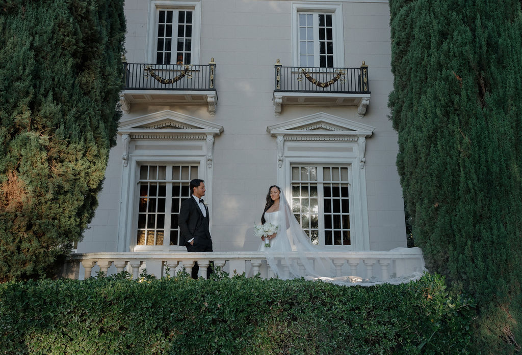 A couple standing on the balcony for wedding photos at Grand Island Mansion