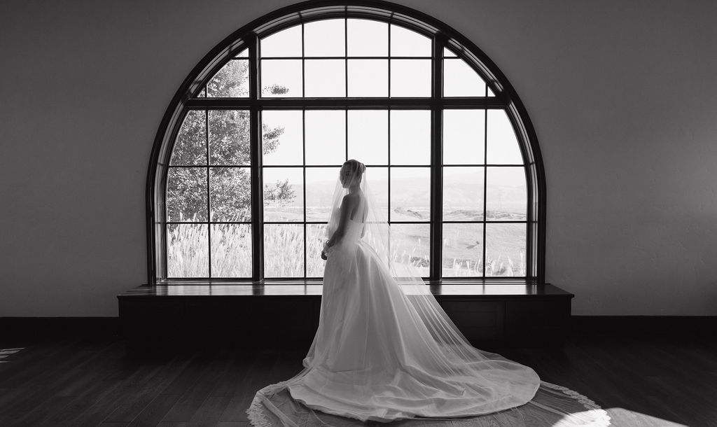 A bride showing luxury wedding ideas for a wedding dress in a black and white bridal portrait