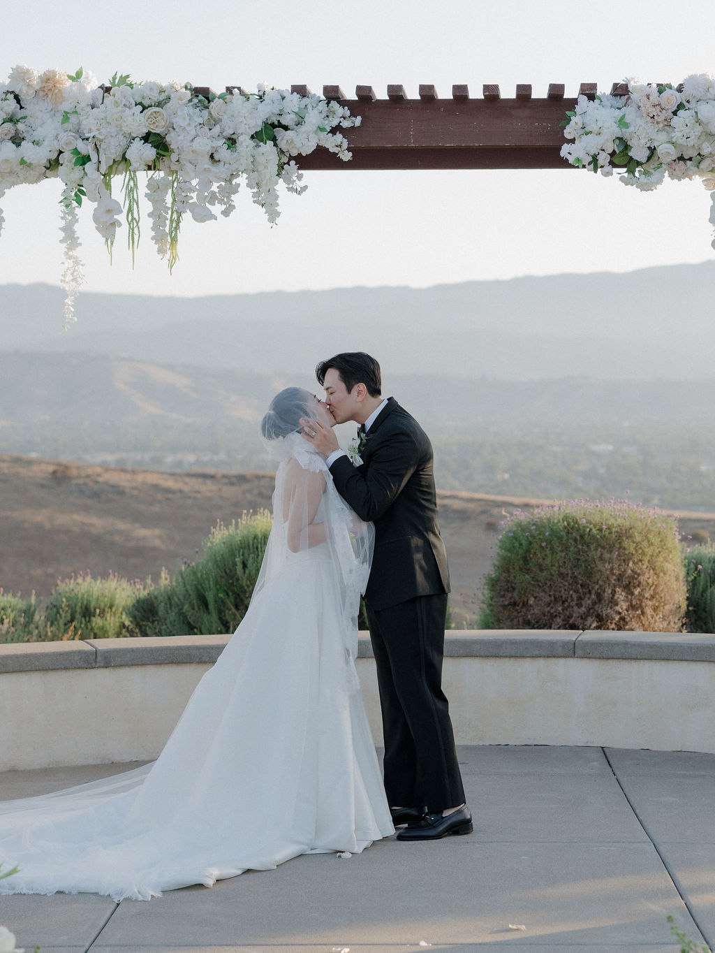 A bride and groom sharing their first kiss at California wedding venue the ranch at silver creek