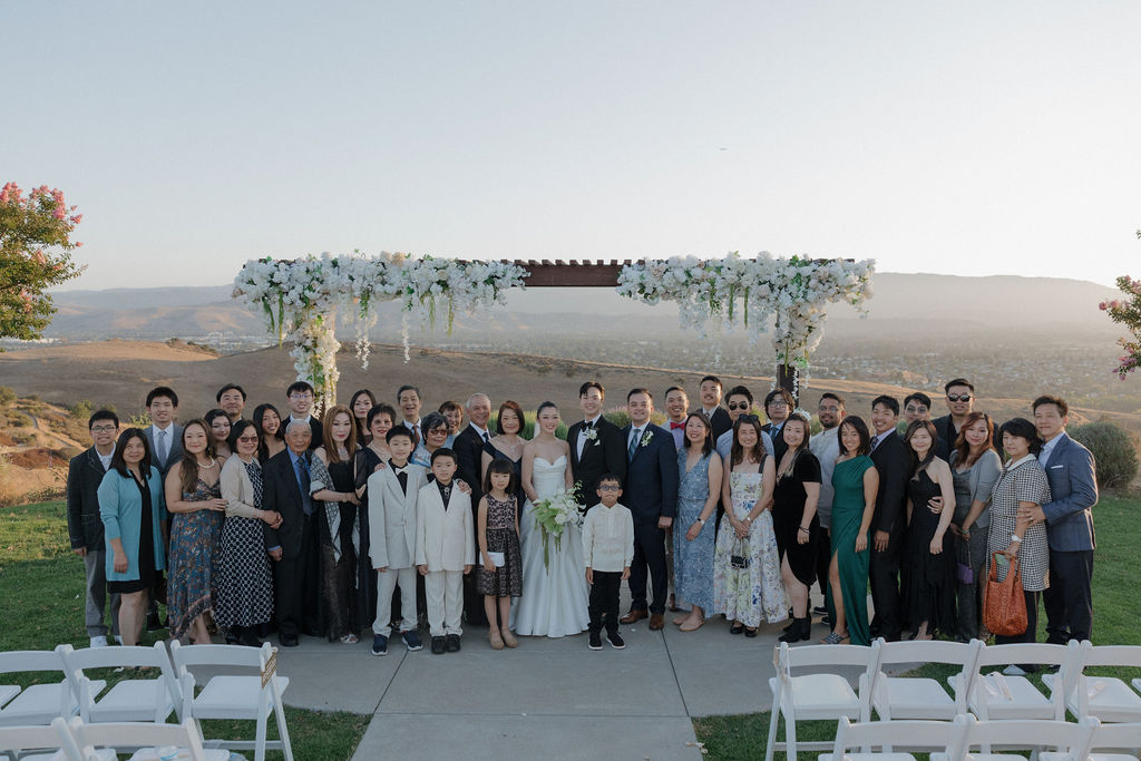 A wedding couple posing with all of their wedding guests