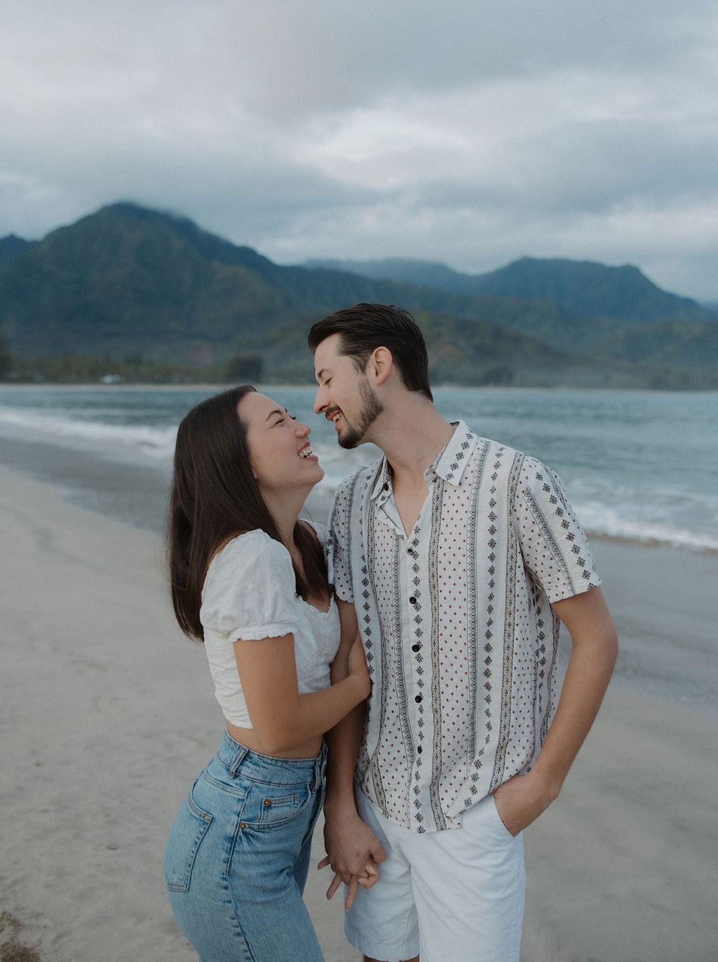 A couple laughing during beach engagement photos