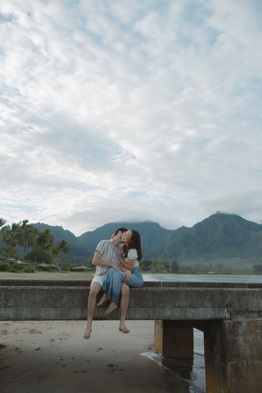 A couple sitting on Hanalei Bay Pier