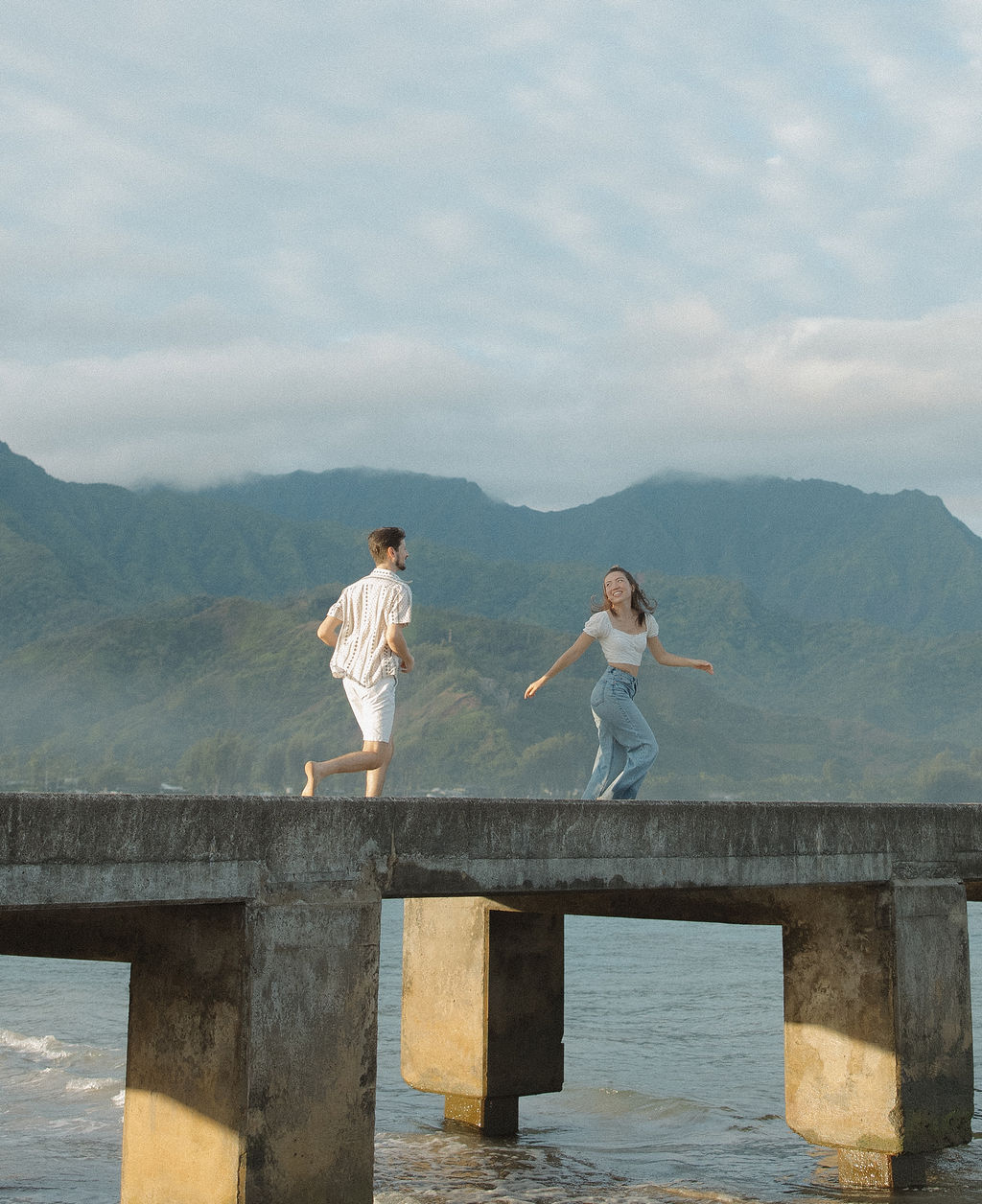 A couple running on a pier in Hawaii
