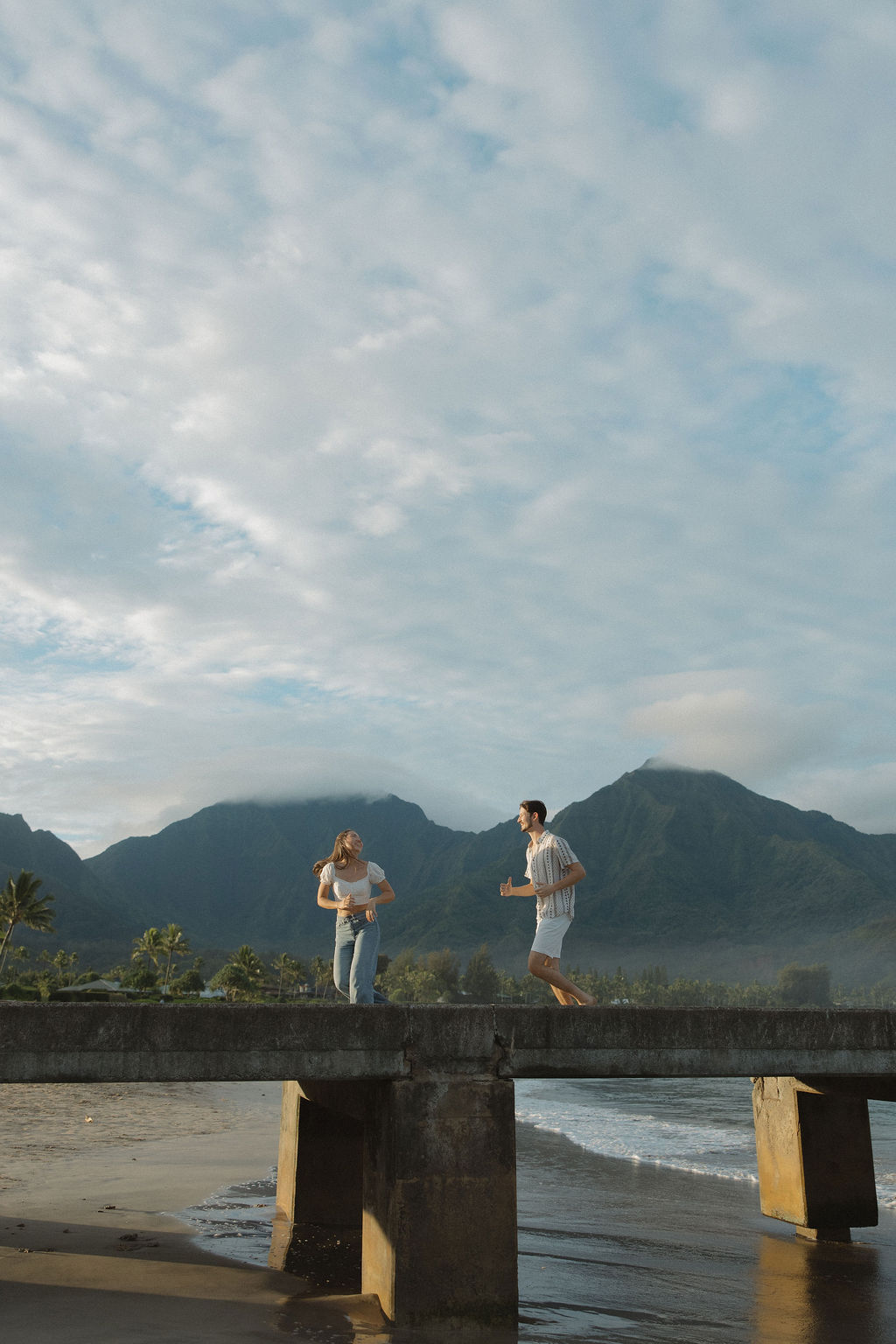 A couple running on a pier in Hawaii