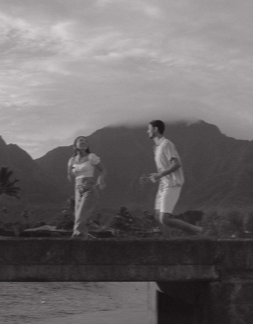 A couple running on Hanalei Bay Pier in a photo taken by a Kauai Photographer