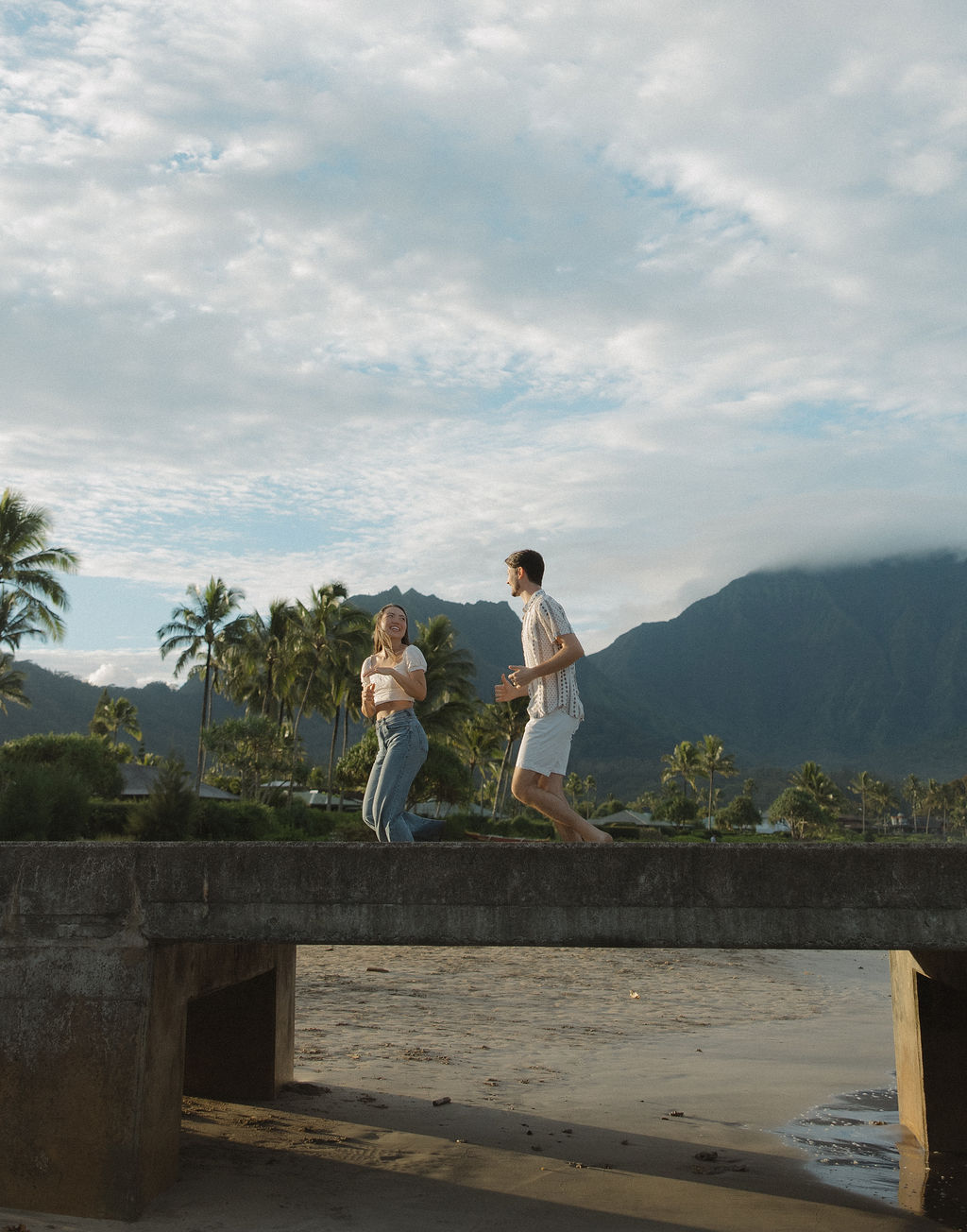 A couple running on Hanalei Bay Pier in a photo taken by a Kauai Photographer