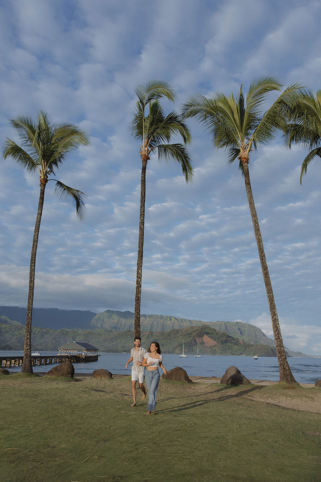 A couple running during Hanalei Bay engagement photos