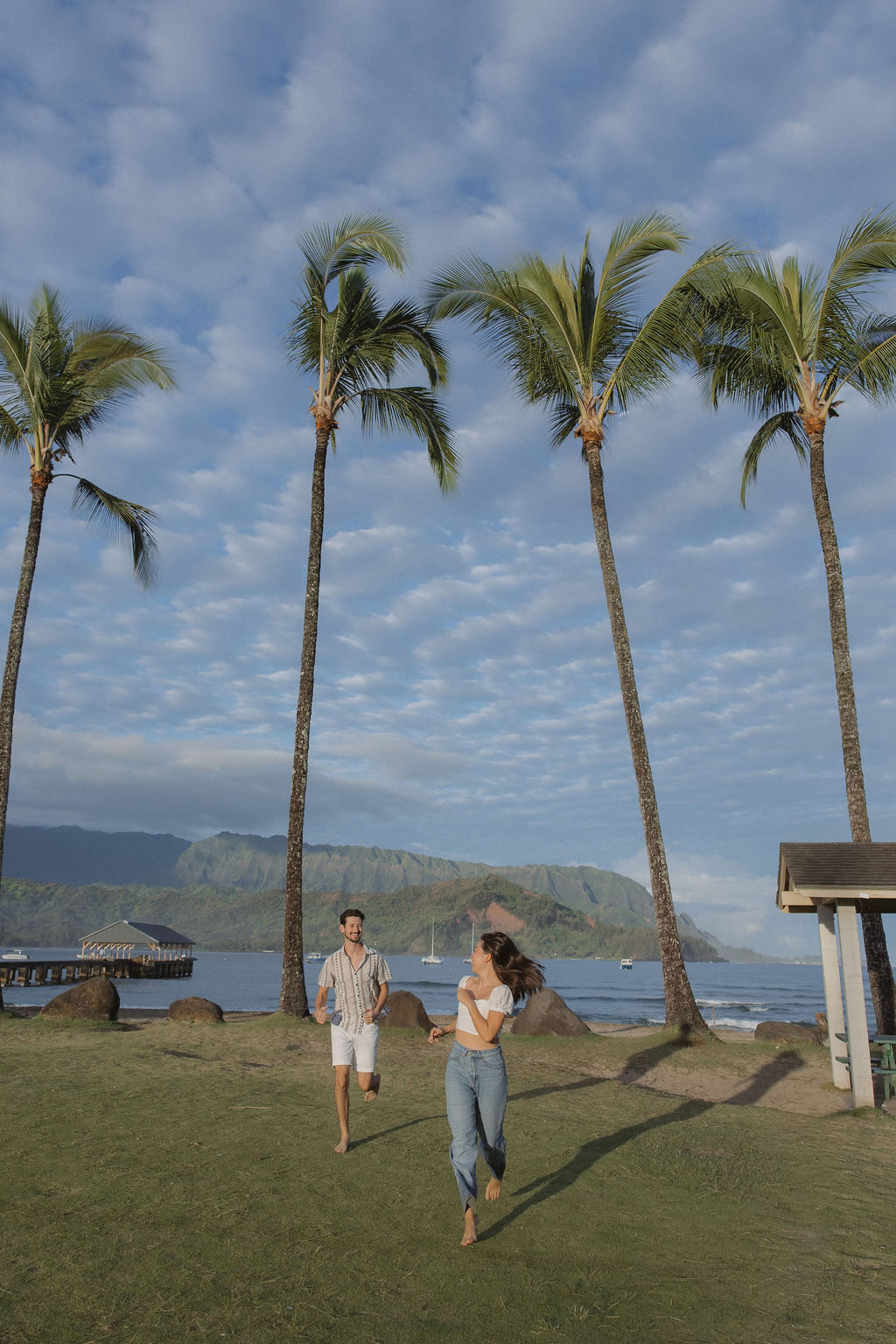 A couple running during Hanalei Bay engagement photos