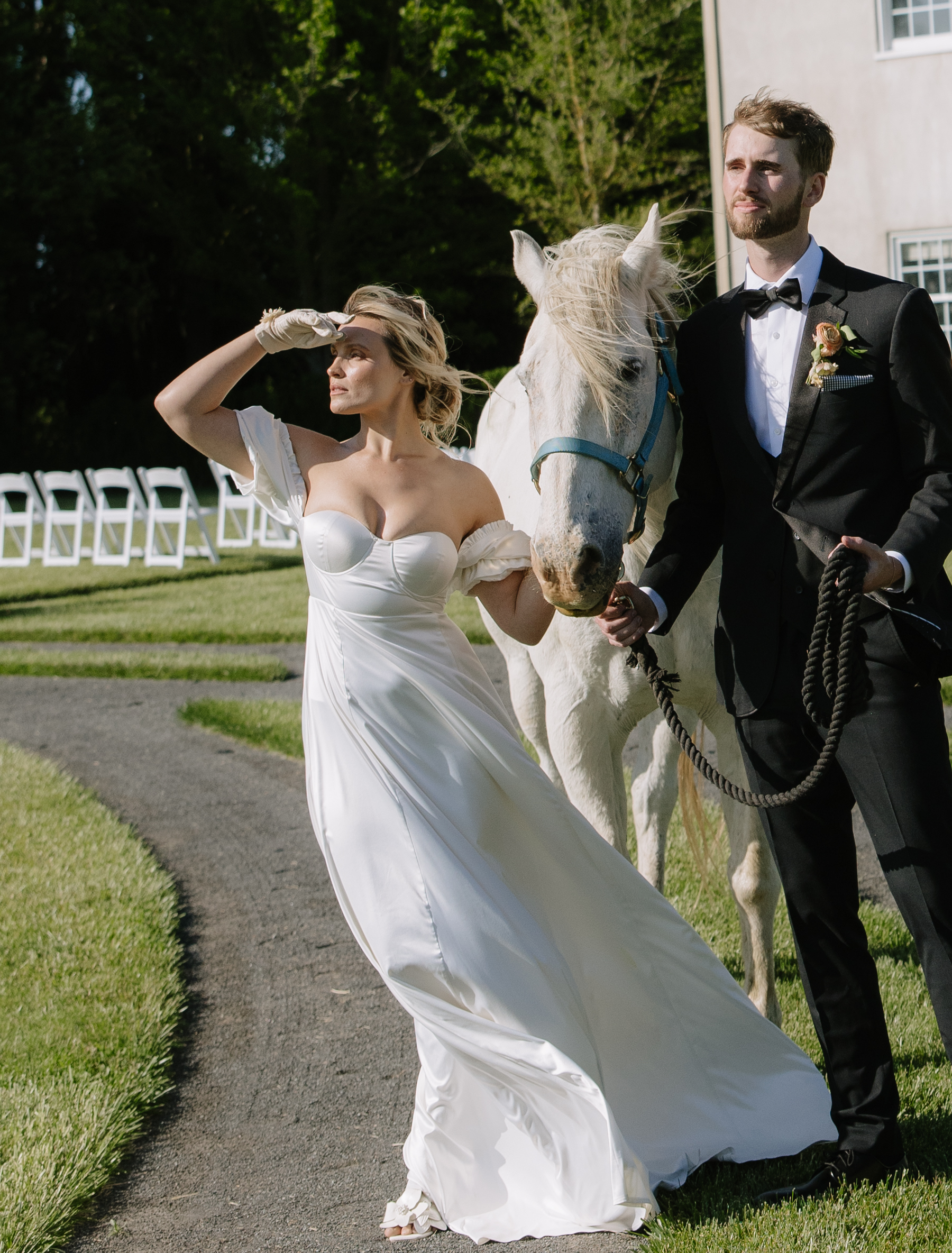 A bride and groom posing for photos with a horse at CAvaignac, their NorCal wedding venue