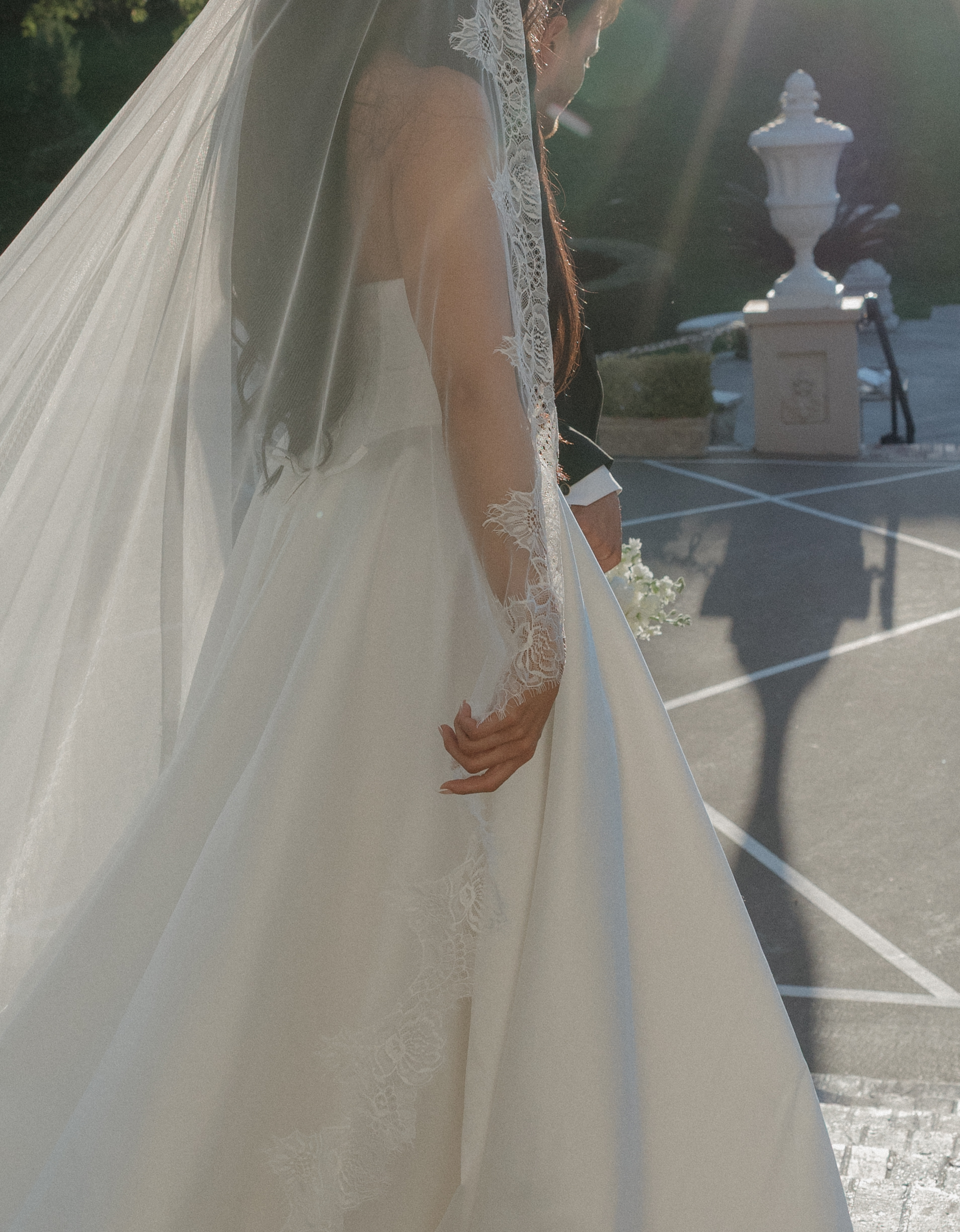 A bride and groom walking across the courtyard at Grand Island mansion