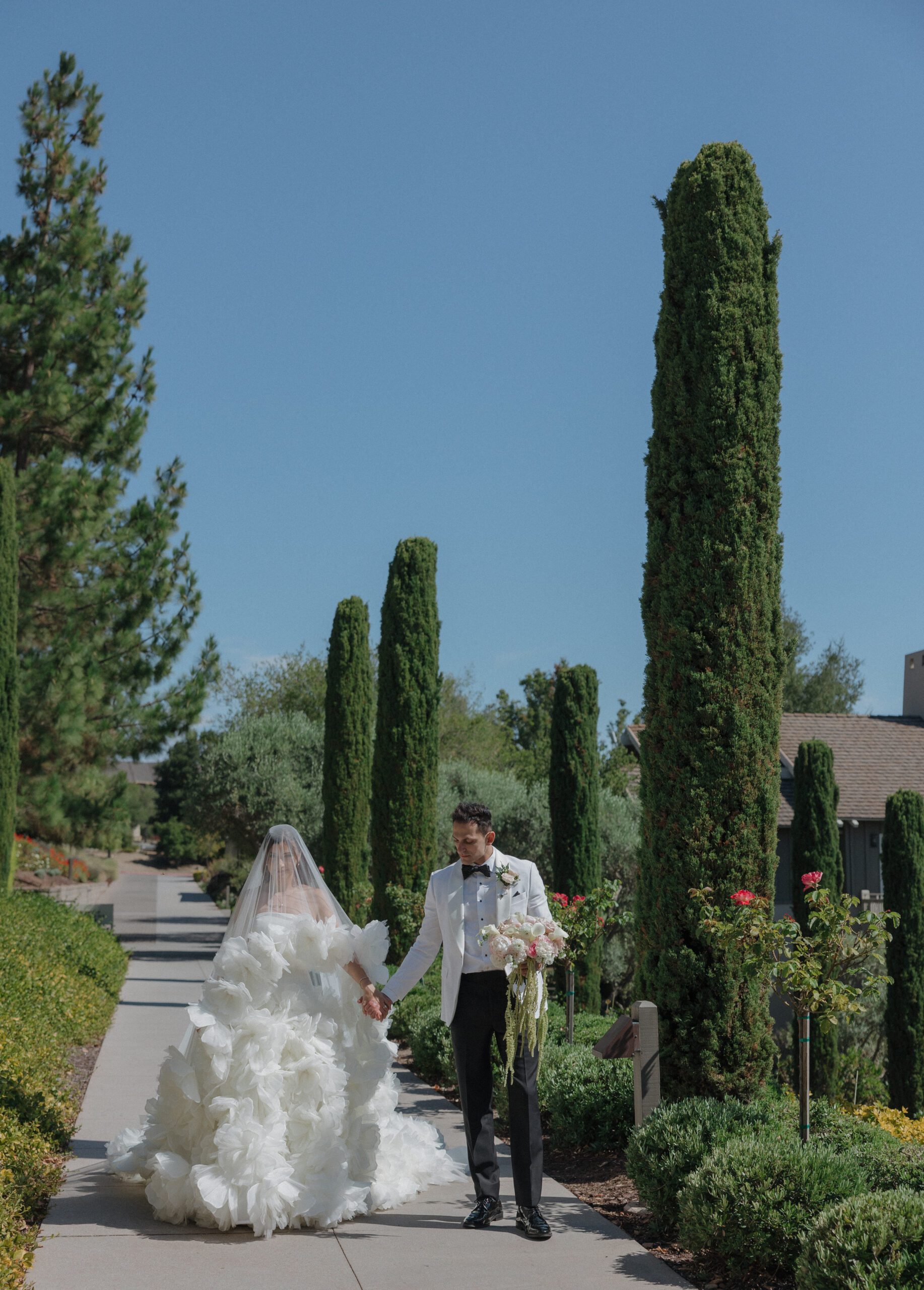 a couple walking through the gardens at Rosewood Sand Hill