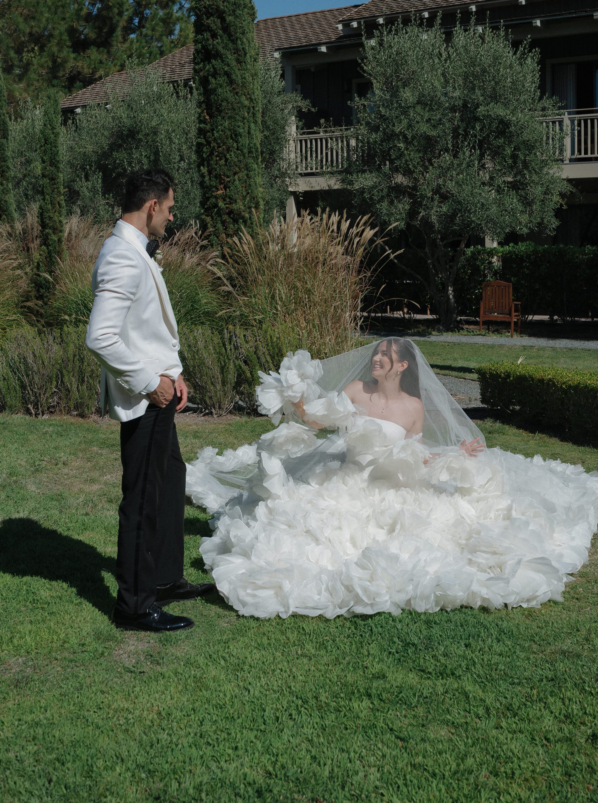 A couple posing for portraits on the lawn of their NorCal wedding venue, Rosewood Sand Hill