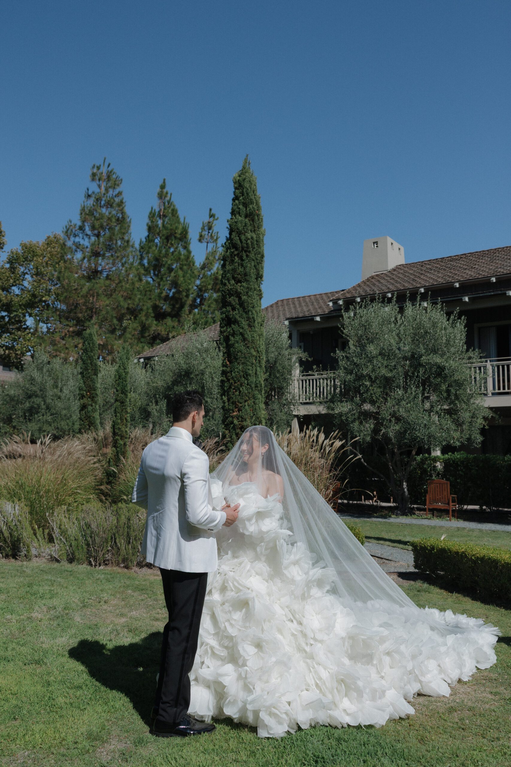 A couple posing for portraits on the lawn of their NorCal wedding venue, Rosewood Sand Hill