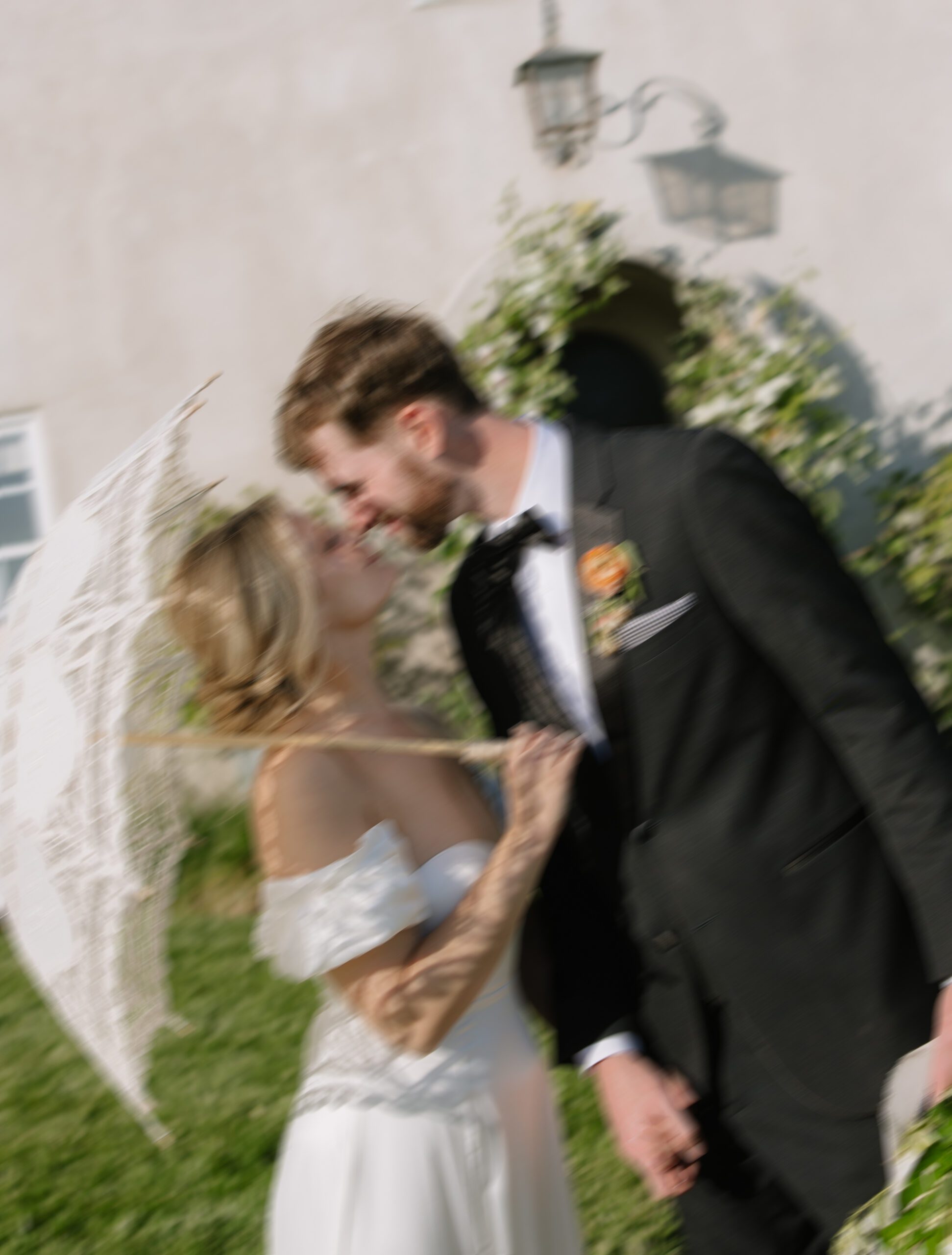 A blurry editorial wedding photo of a bride and groom kissing at Cavaignac