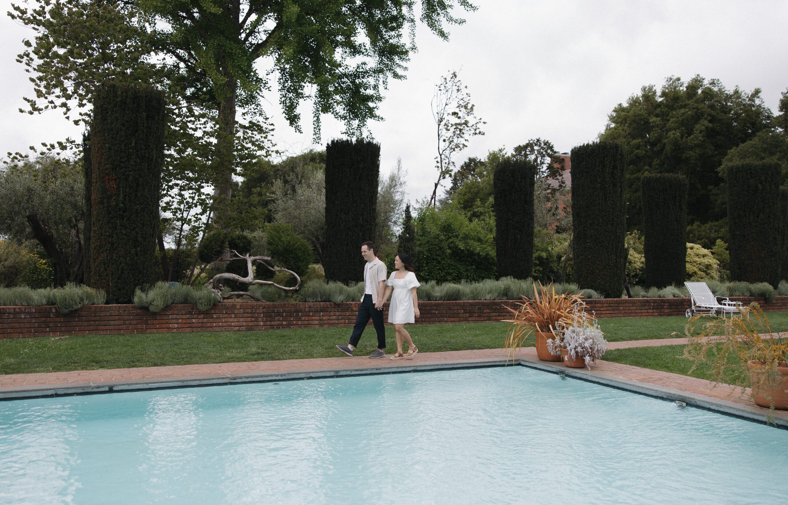 A couple walking by the pool beside Filoli