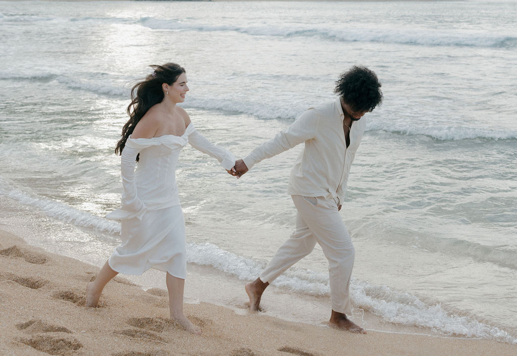 A bride and groom walking on Tunnels Beach after their Hawaii elopement