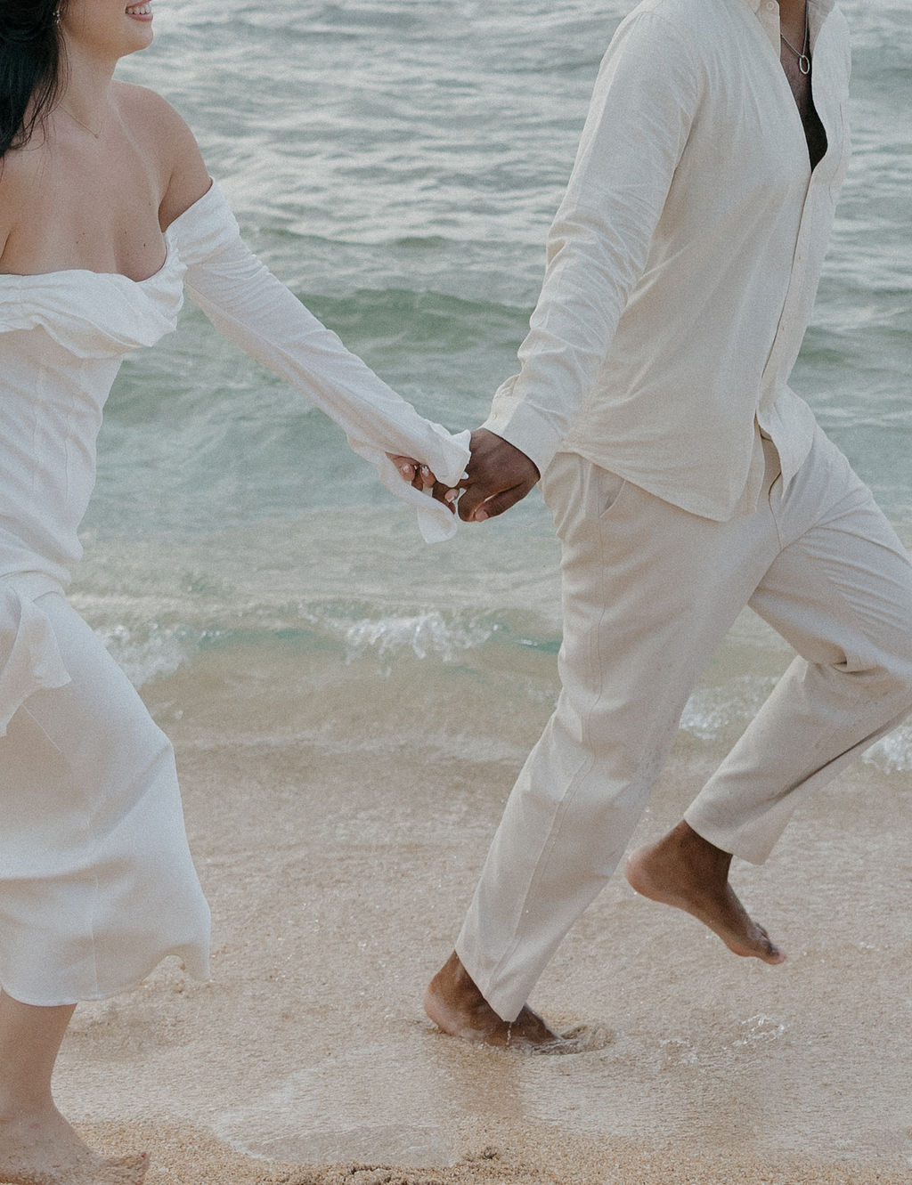 A couple running on a Kauai beach during elopement photos