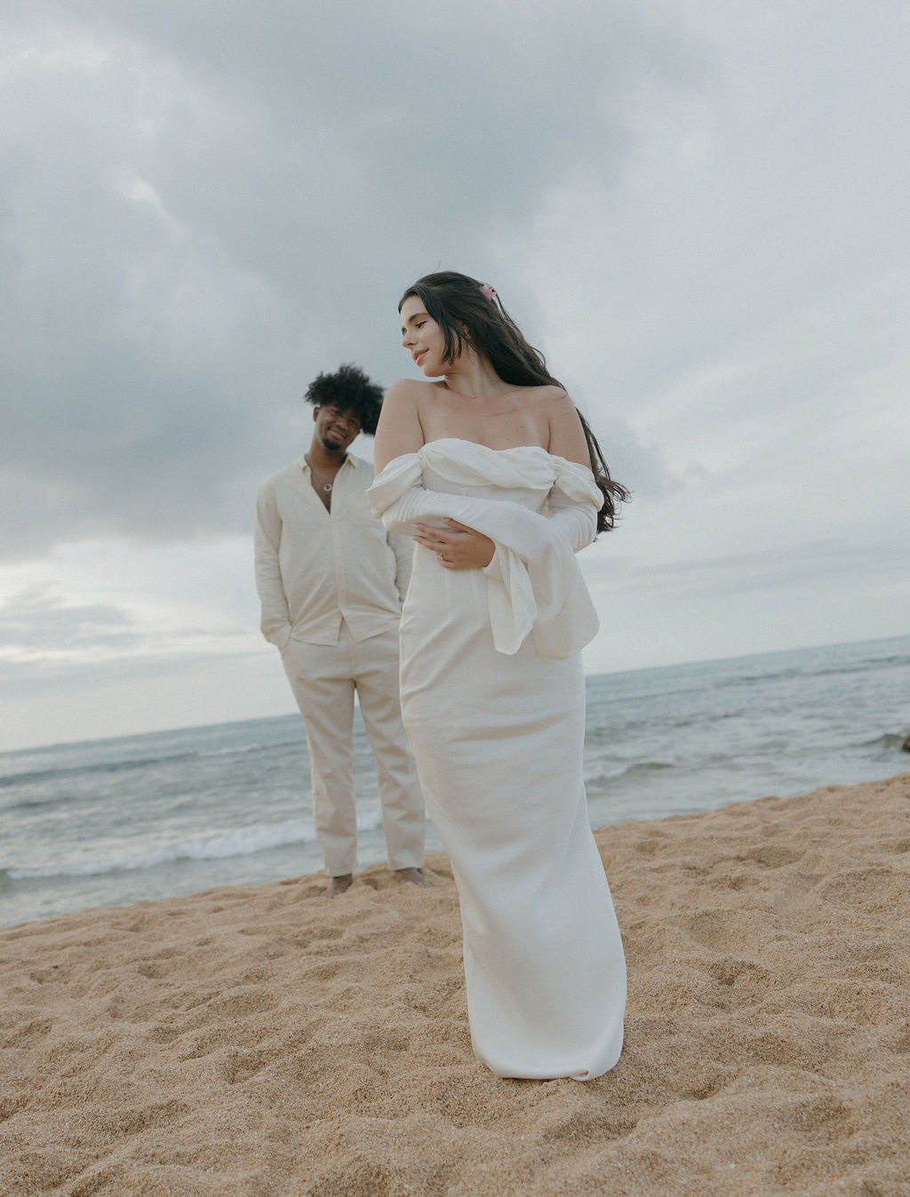 A bride standing in front of a groom for beach elopement photos in Hawaii