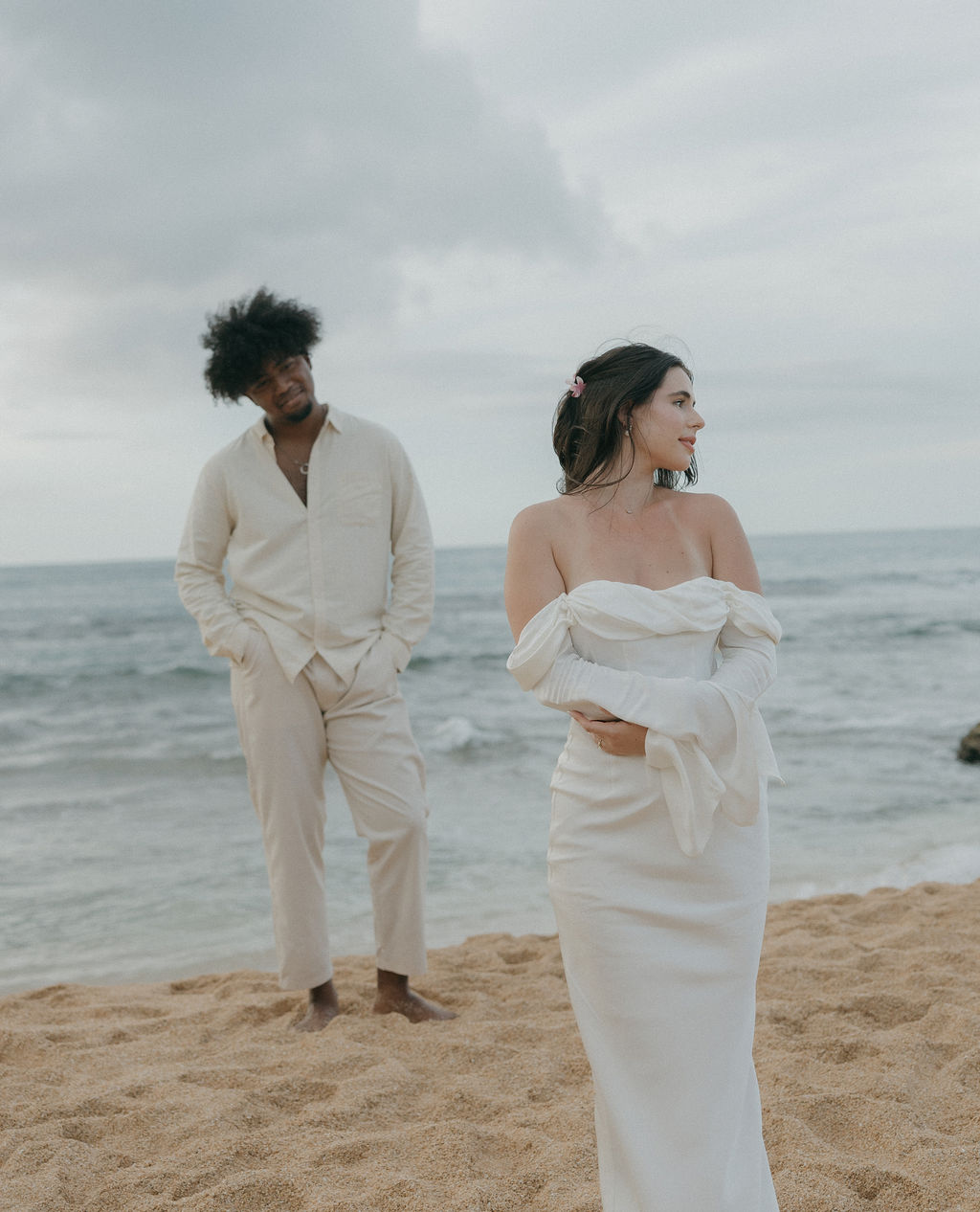 A bride standing in front of a groom for beach elopement photos in Hawaii