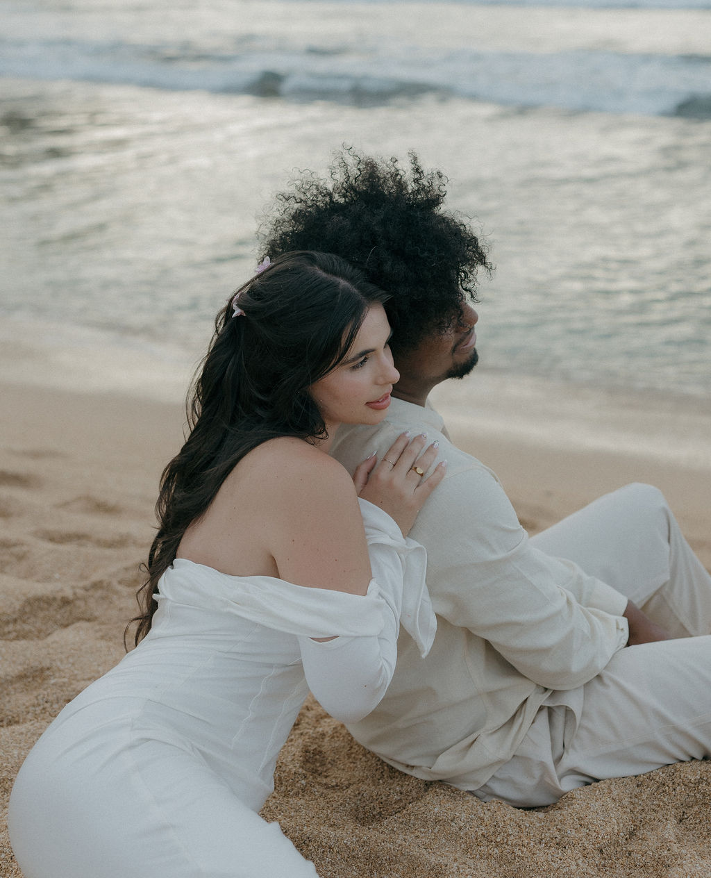A couple sitting on the beach after their Kauai elopement