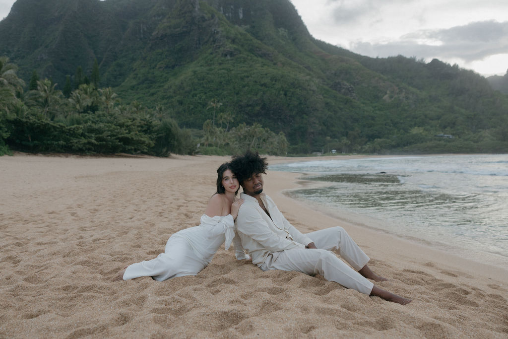 A couple sitting on the beach for their Kauai elopement