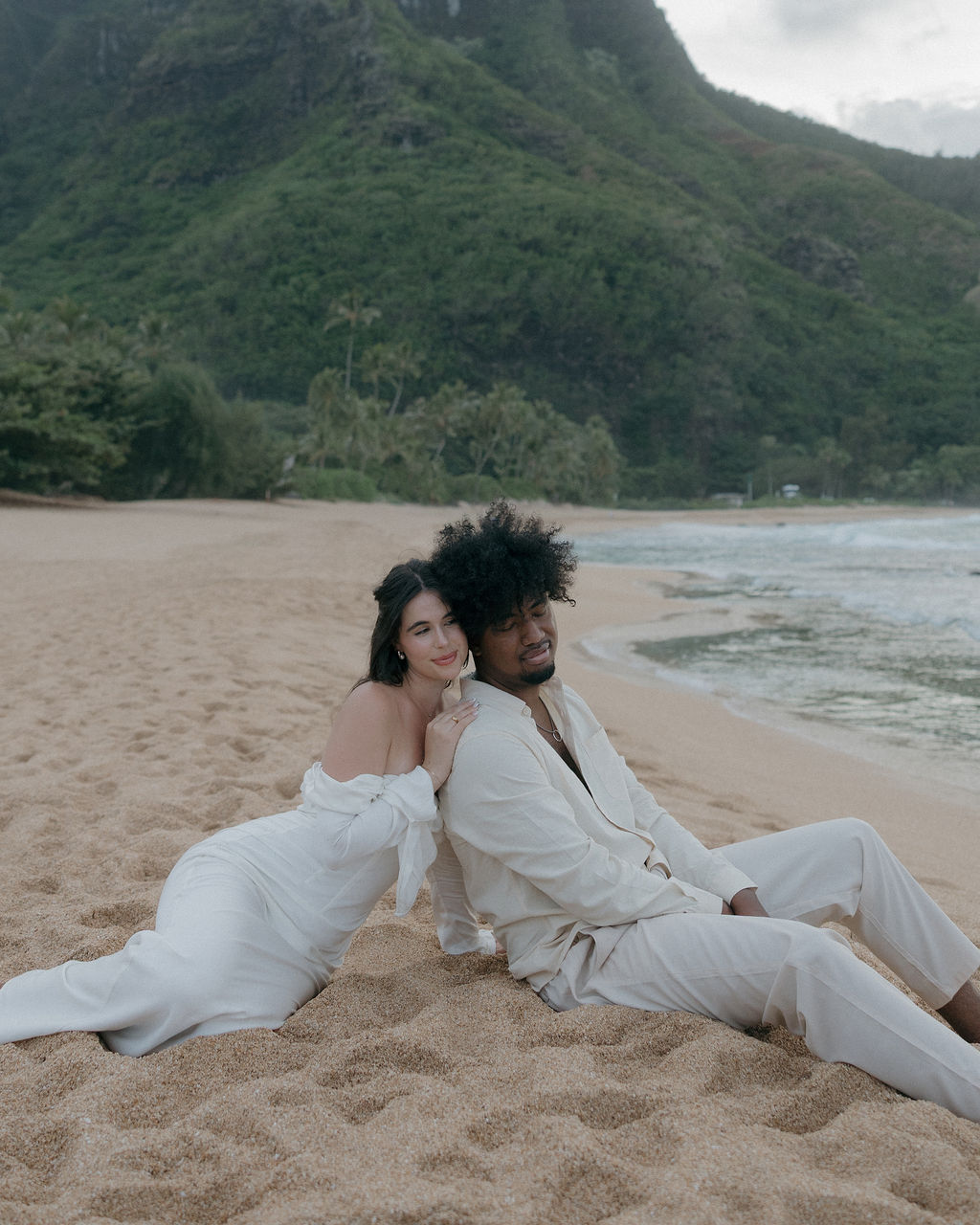 A couple sitting on the beach after their Hawaii elopement