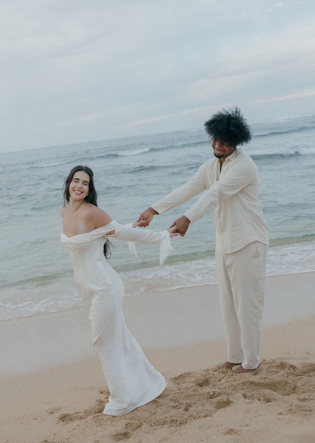 A bride and groom taking beach elopement photos on Tunnels Beach