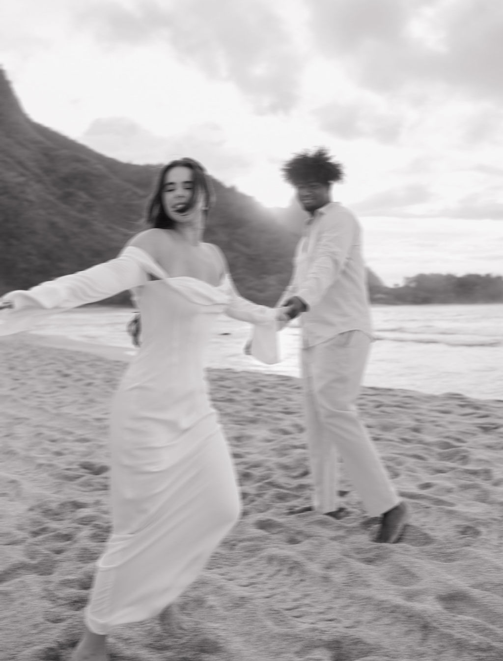 A couple spinning on the beach during Hawaii elopement photos