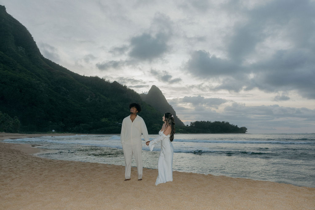 A bride and groom on the beach in a sunset Kauai elopement