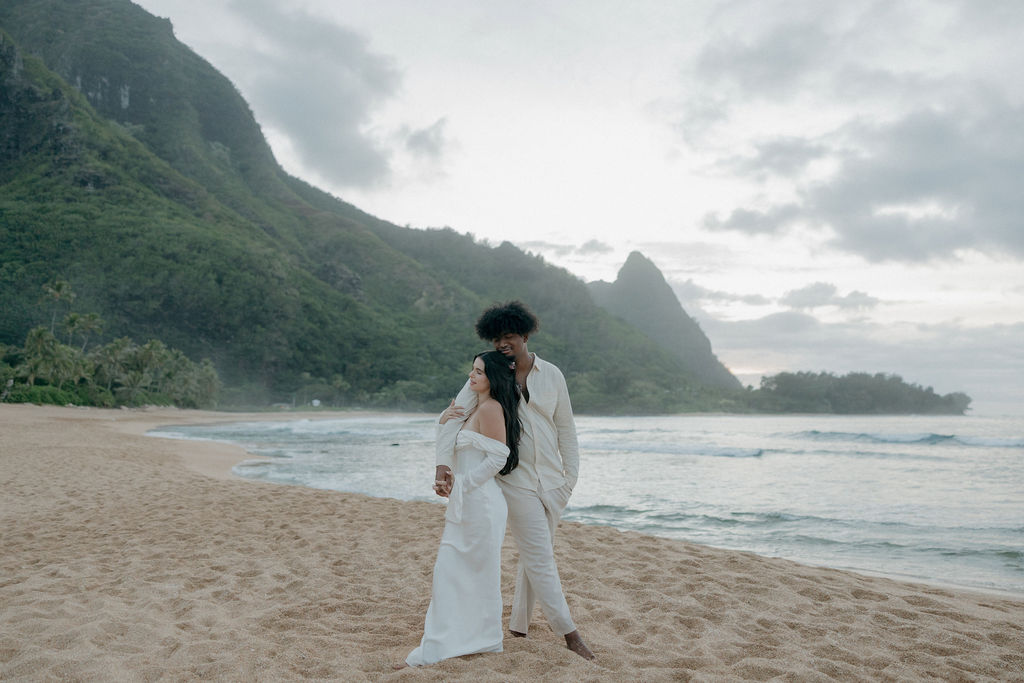 A bride and groom posing for Hawaii Elopement photos on Kauai Tunnels Beach