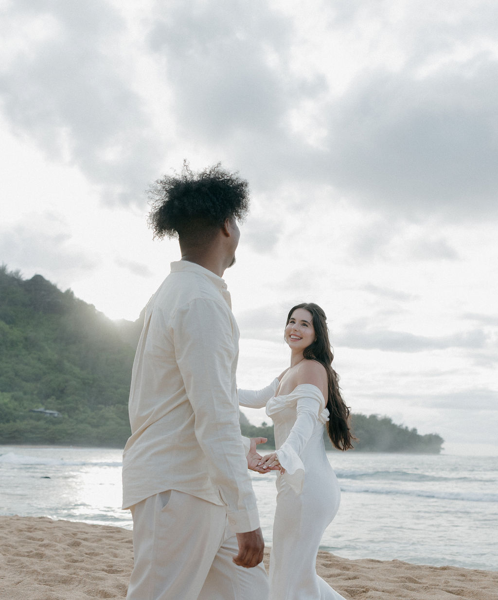 A couple spinning around on a Kauai Beach for elopement photos