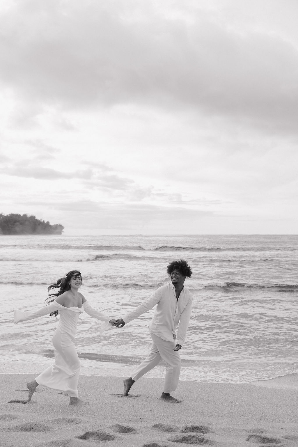 A couple running on the beach during Hawaii elopement photos