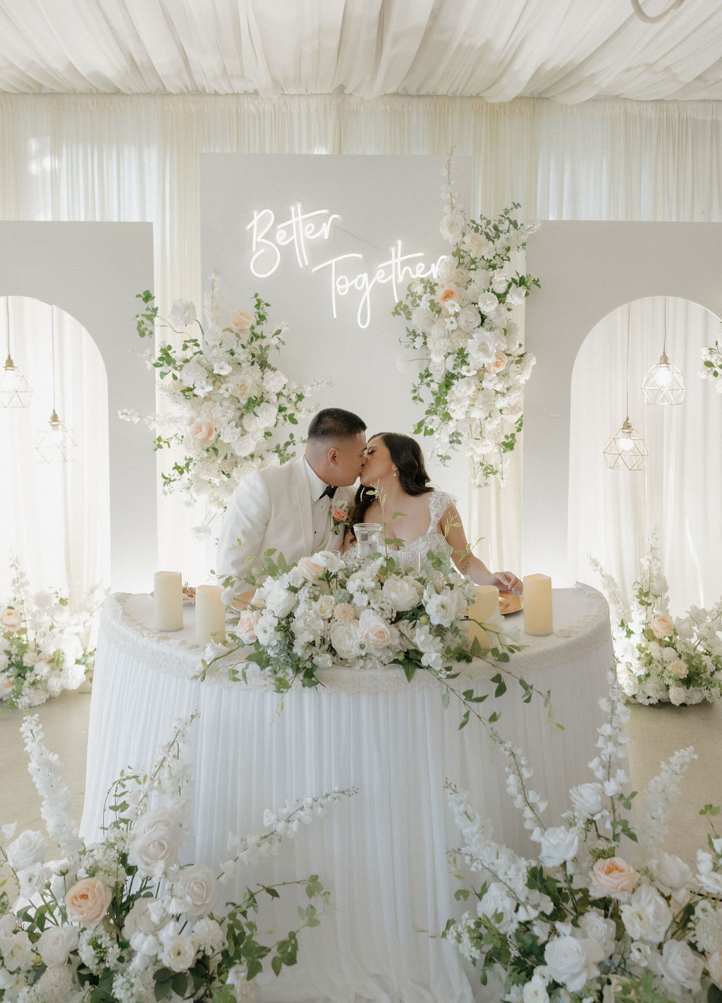 A bride and groom kissing at their sweetheart table