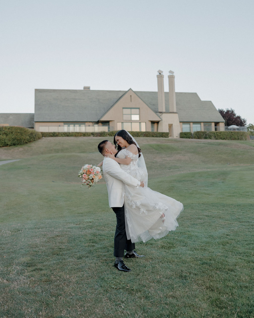A bride and groom posing for wedding photos in front of the California wedding venue they picked off of a wedding vendor checklist
