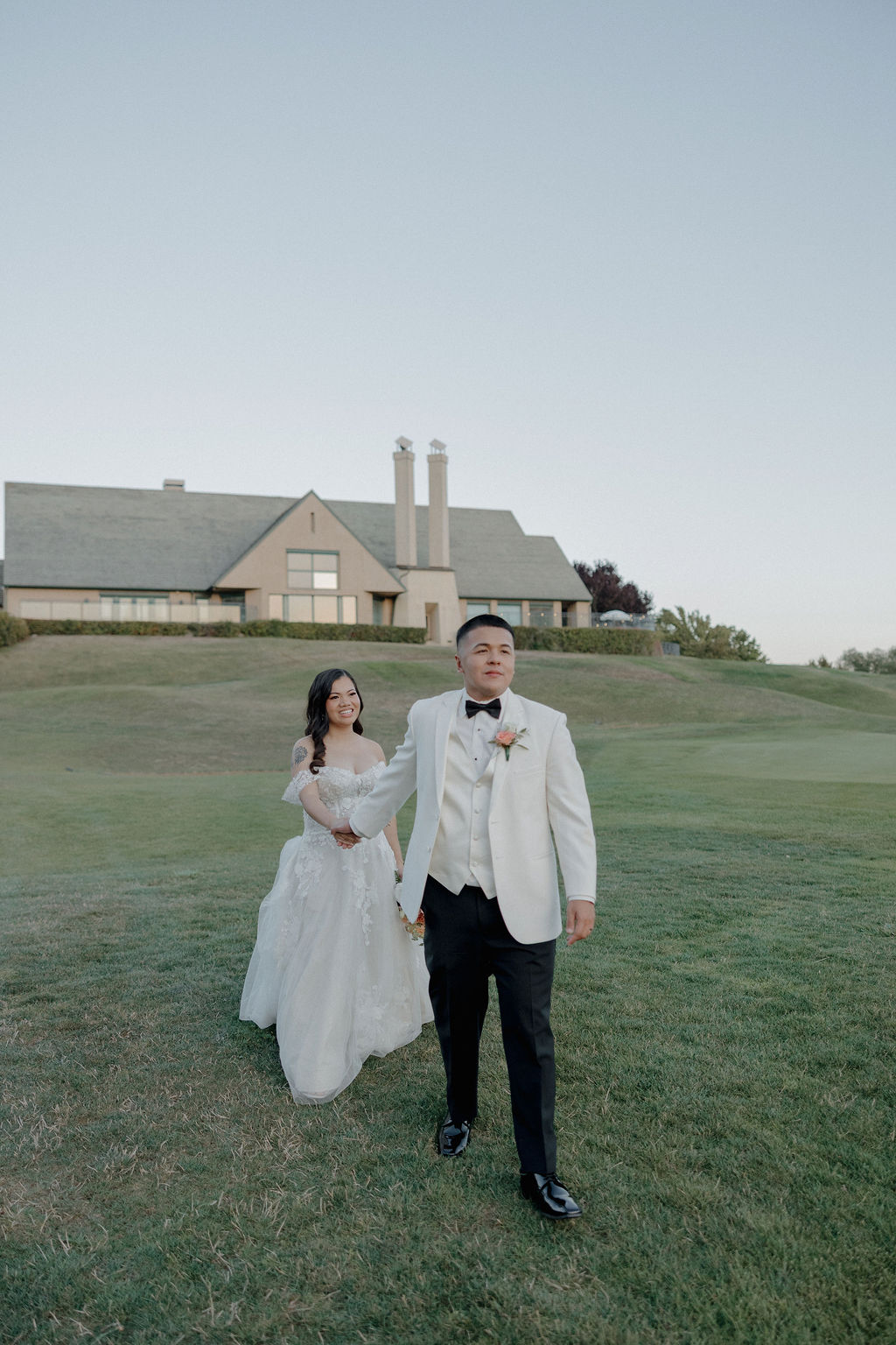 A bride and groom posing for wedding photos in front of the California wedding venue they picked off of a wedding vendor checklist