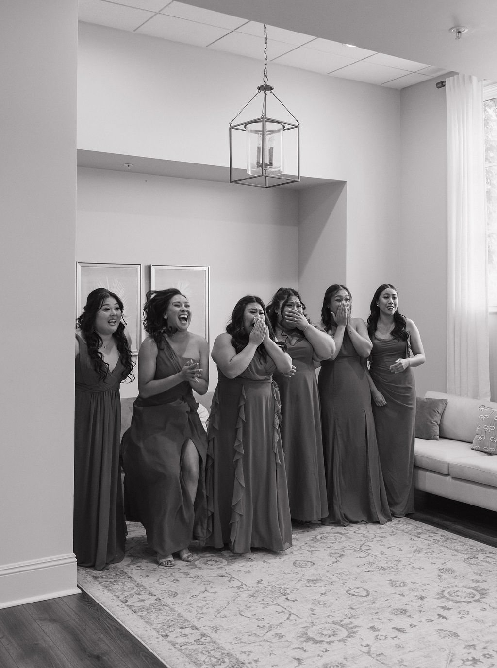 Bridesmaids reacting to a bride in her wedding dress
