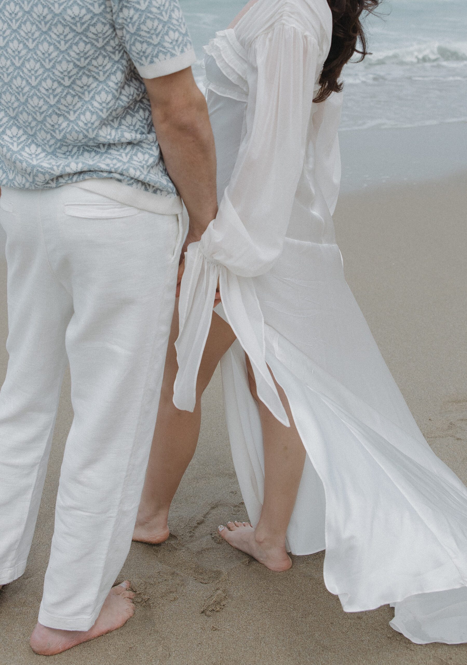 A couple showing off engagement photo shoot outfit ideas for beach engagement photos