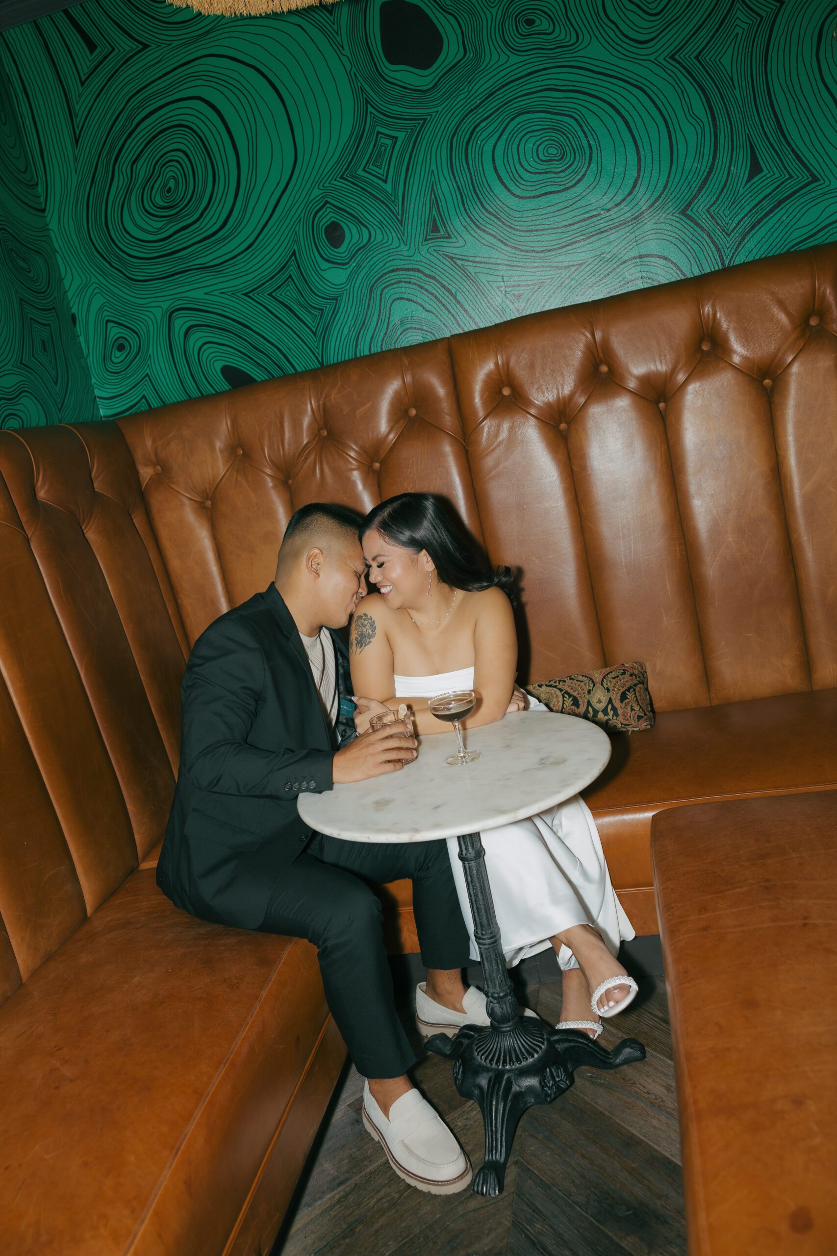 A couple in a booth for bar engagement photos