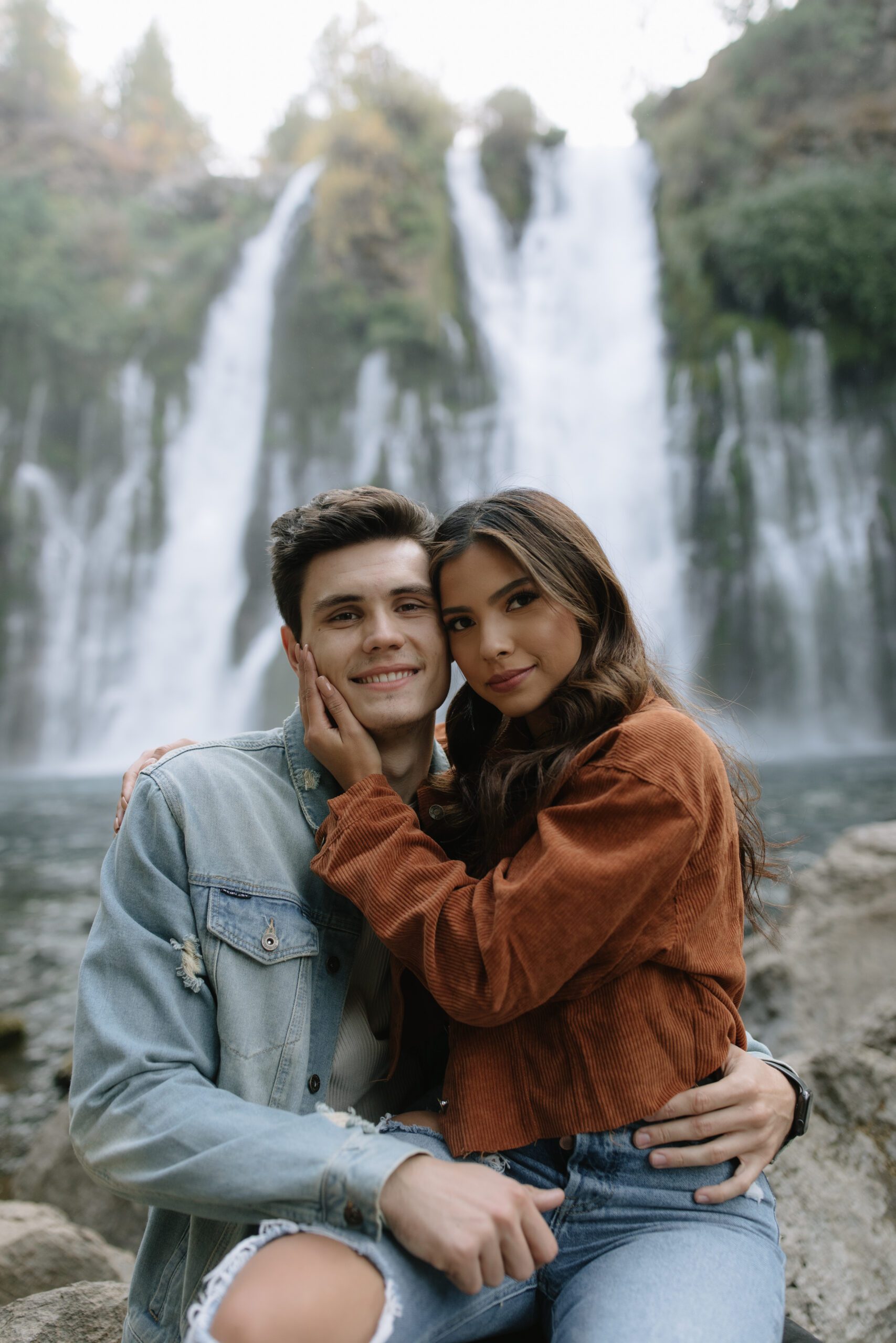 A couple posing for mountain engagement photos
