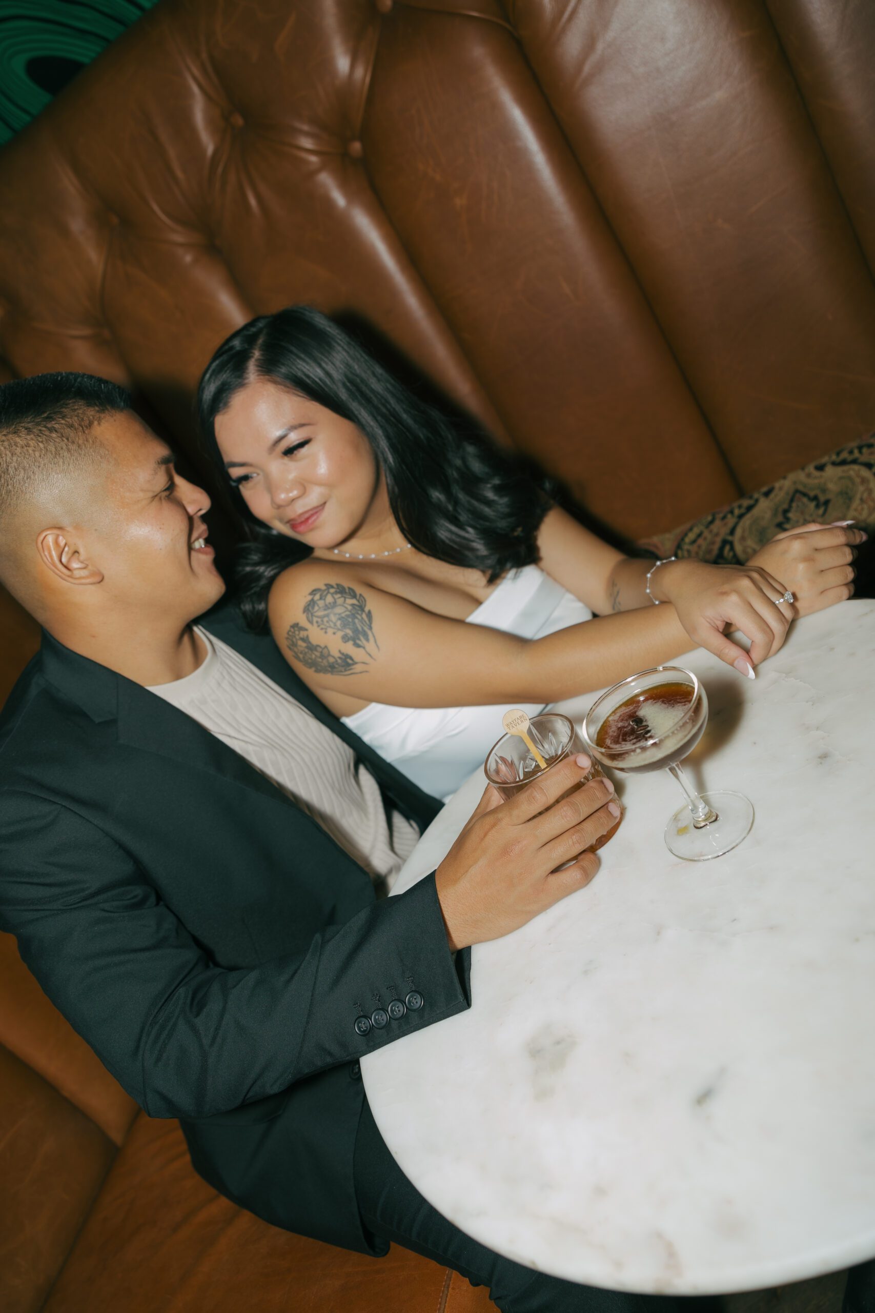 A couple in a booth for bar engagement photos