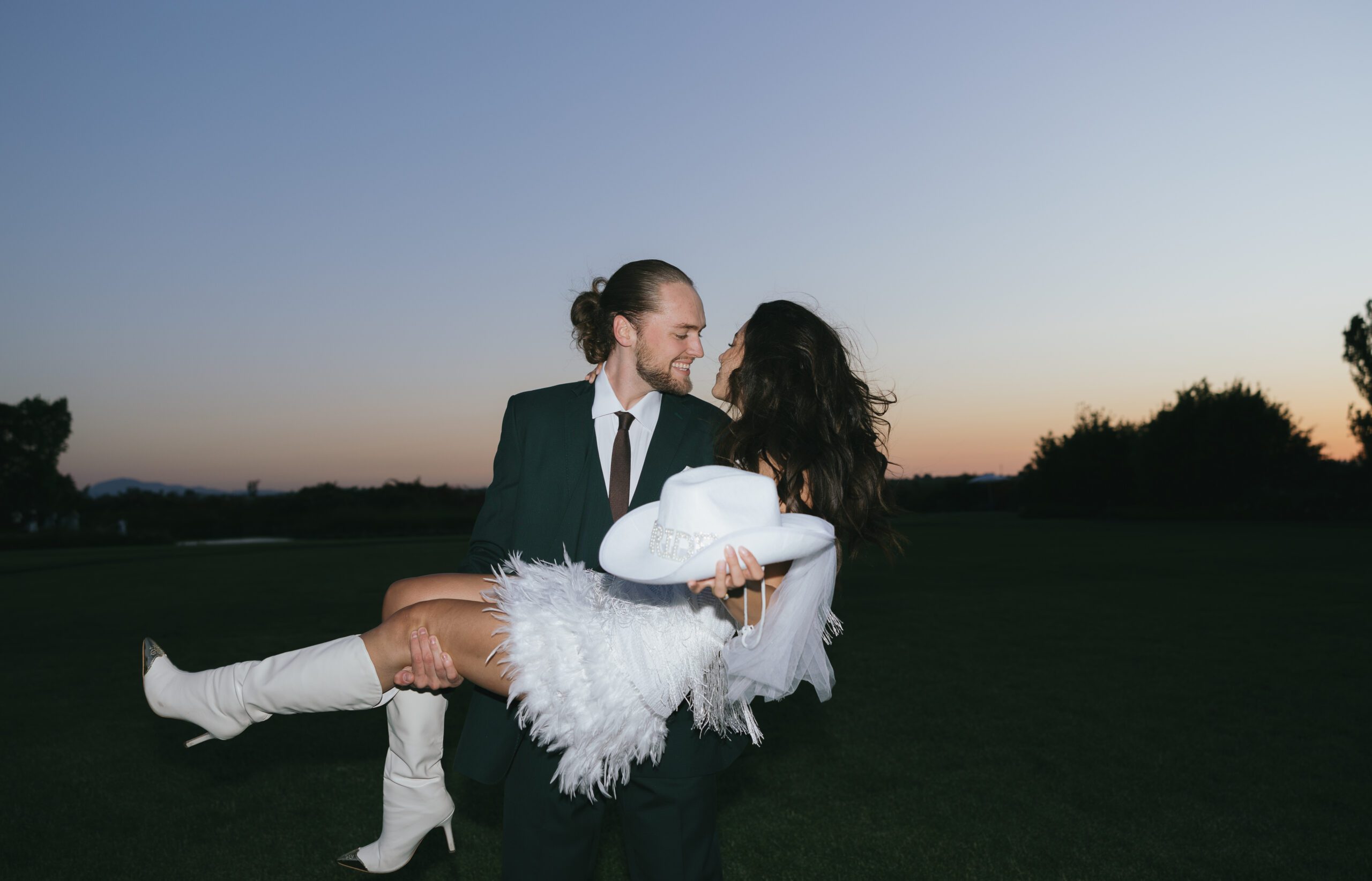 A couple wearing funky engagement photo shoot outfits for a western themed engagement photo shoot