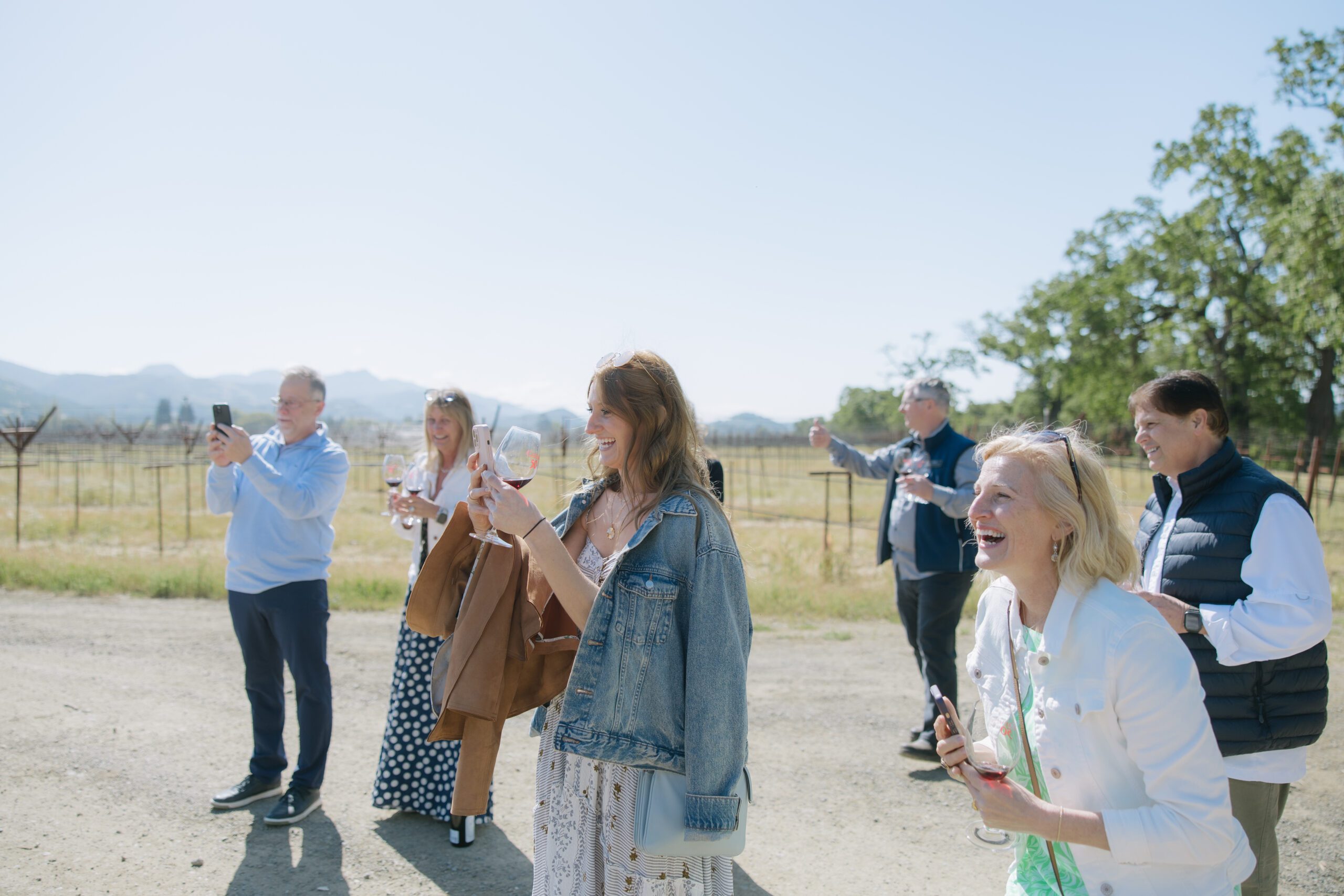 A family taking photos of a couple getting engaged