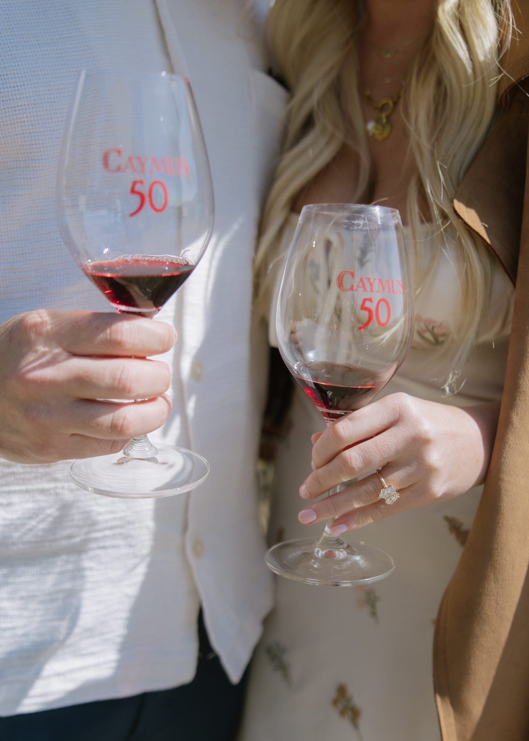 A couple holding wine glasses after getting engaged