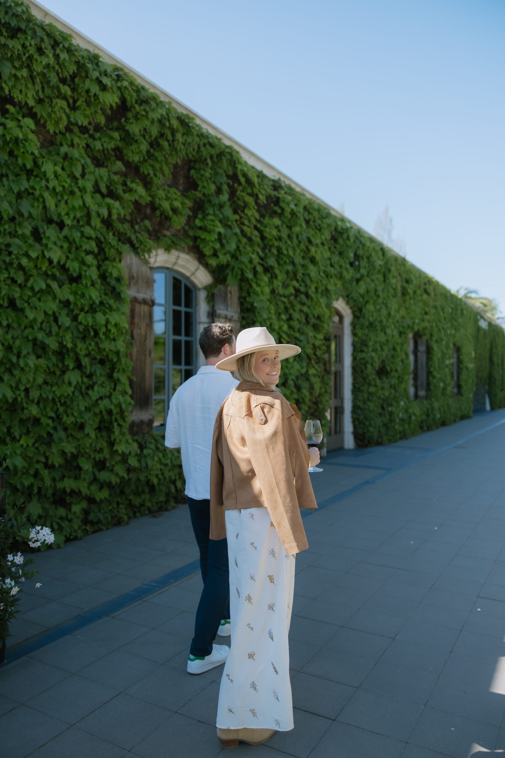 A couple walking through a vineyard taking engagement photos