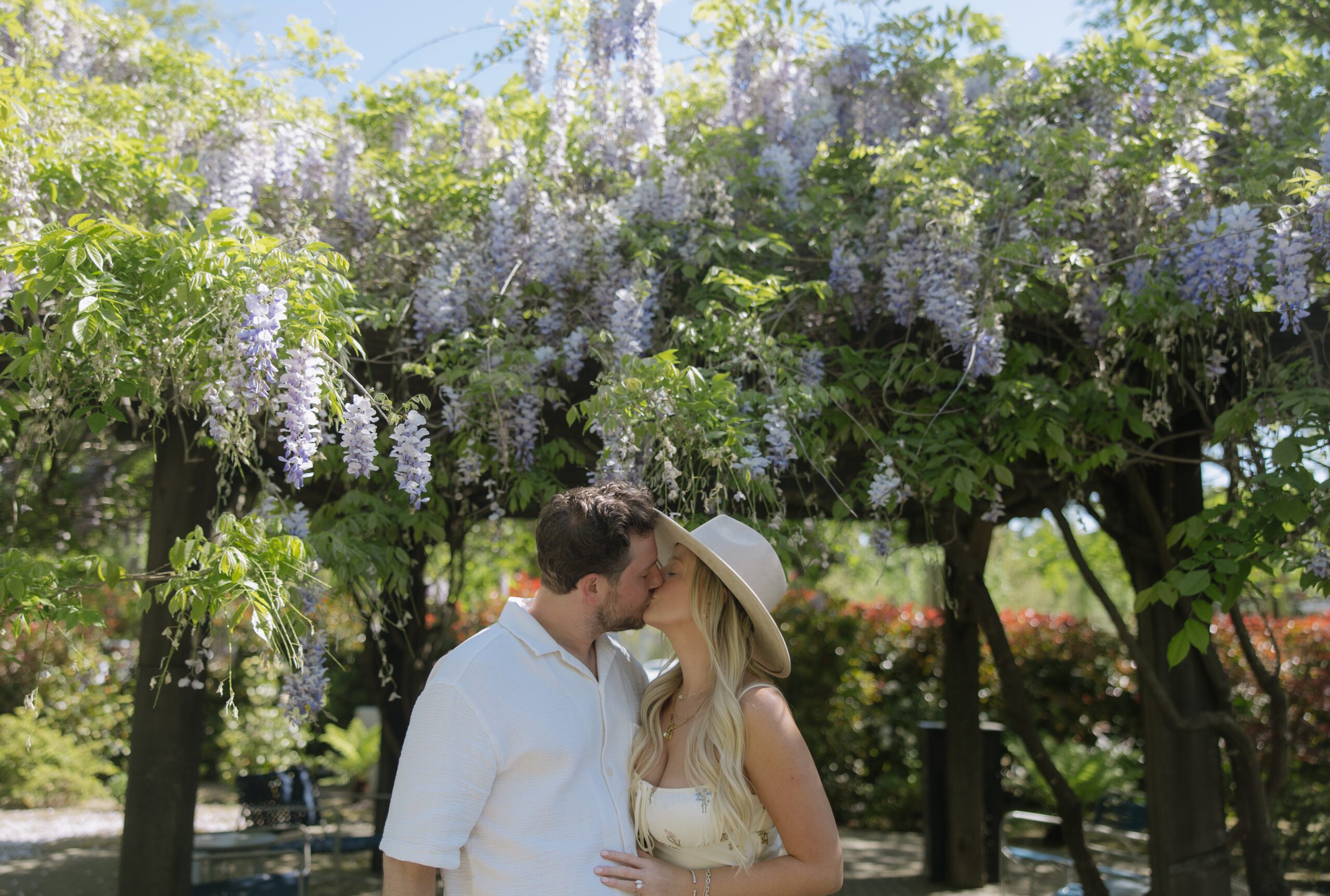 A couple kissing at a vineyard after living out romantic proposal ideas