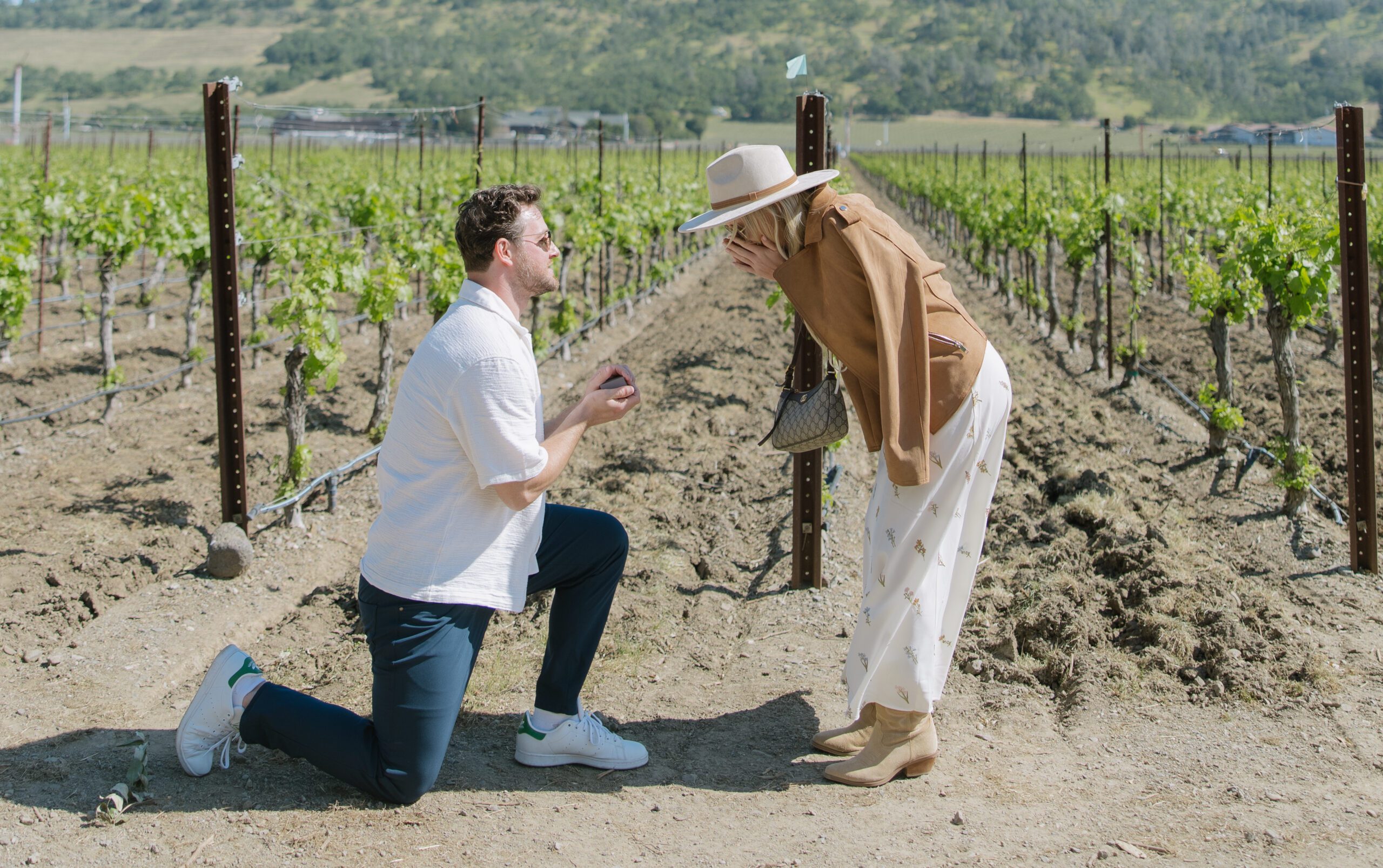 A man on his knee proposing to his fiancee, showing off romantic proposal ideas