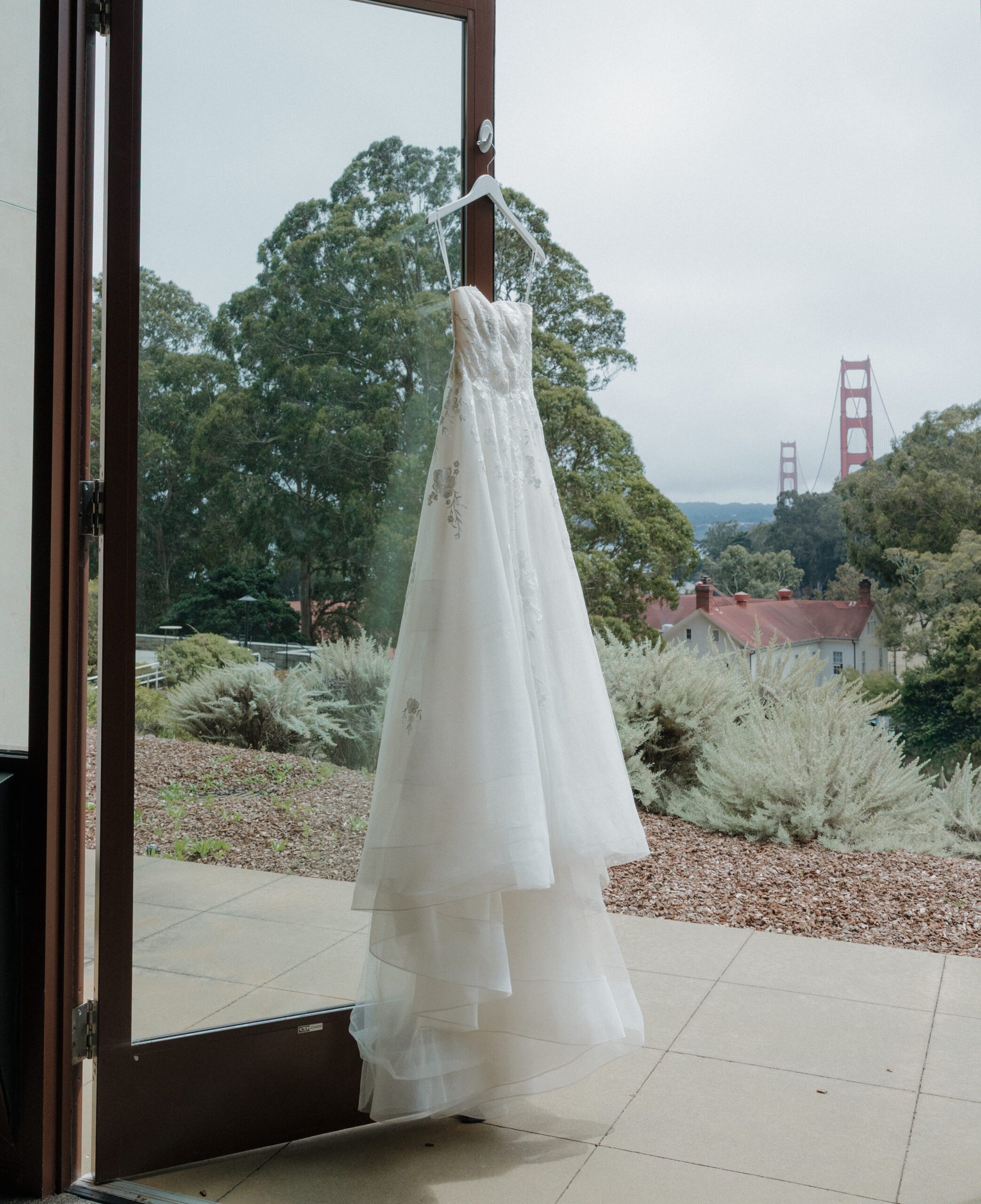A wedding dress hanging up with the Golden Gate Bridge in the background