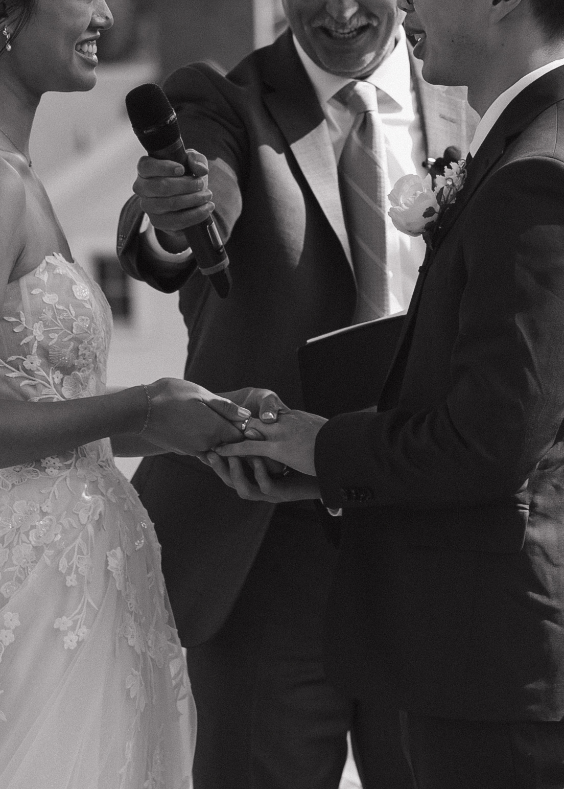 A close-up photo of a bride and groom holding hands during their wedding ceremony