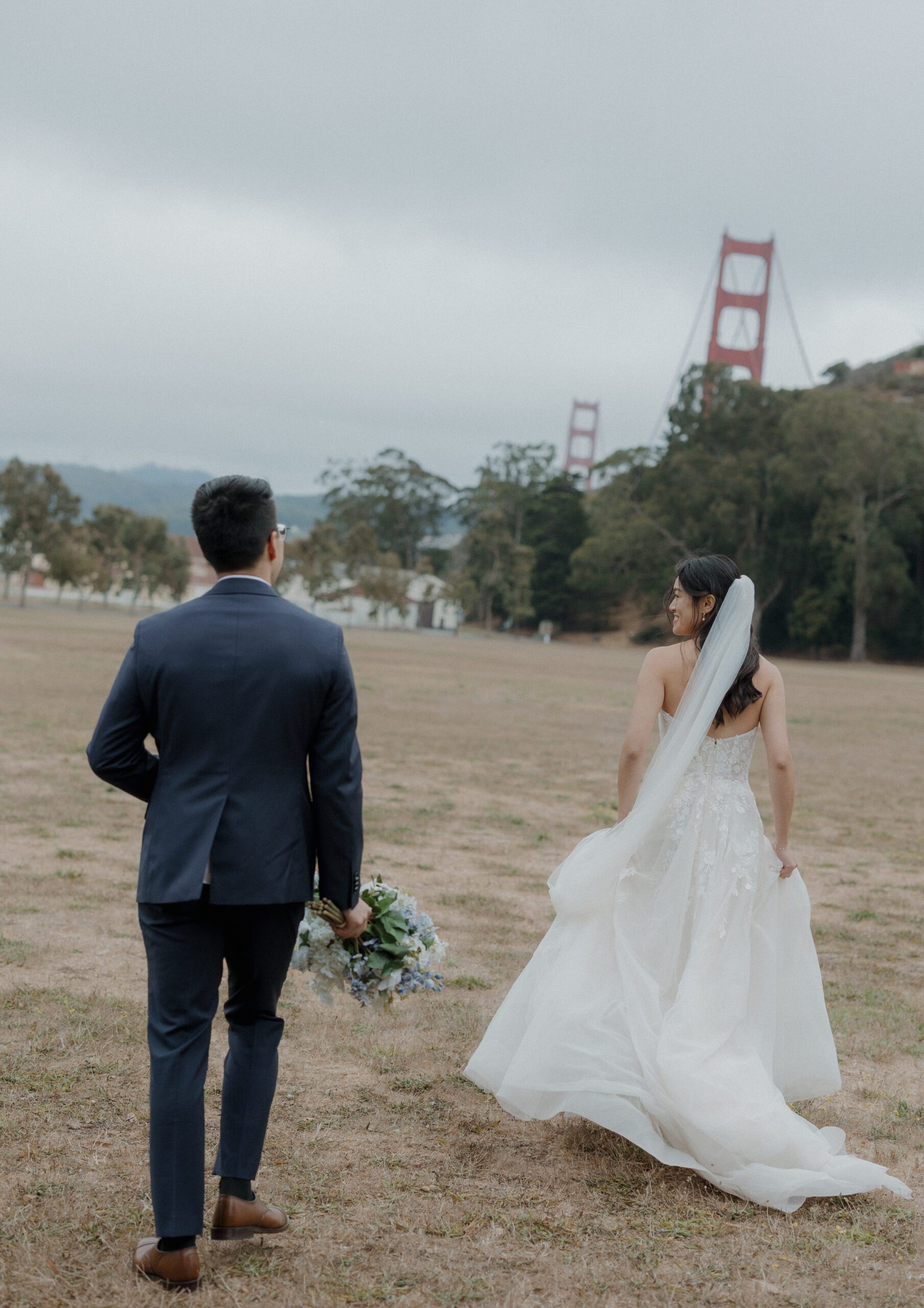 A bride and groom running through a field for Cavallo Point Lodge wedding photos