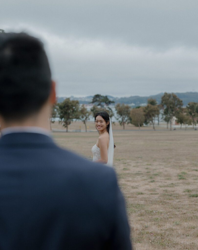 A bride and groom running through a field for Cavallo Point Lodge wedding photos